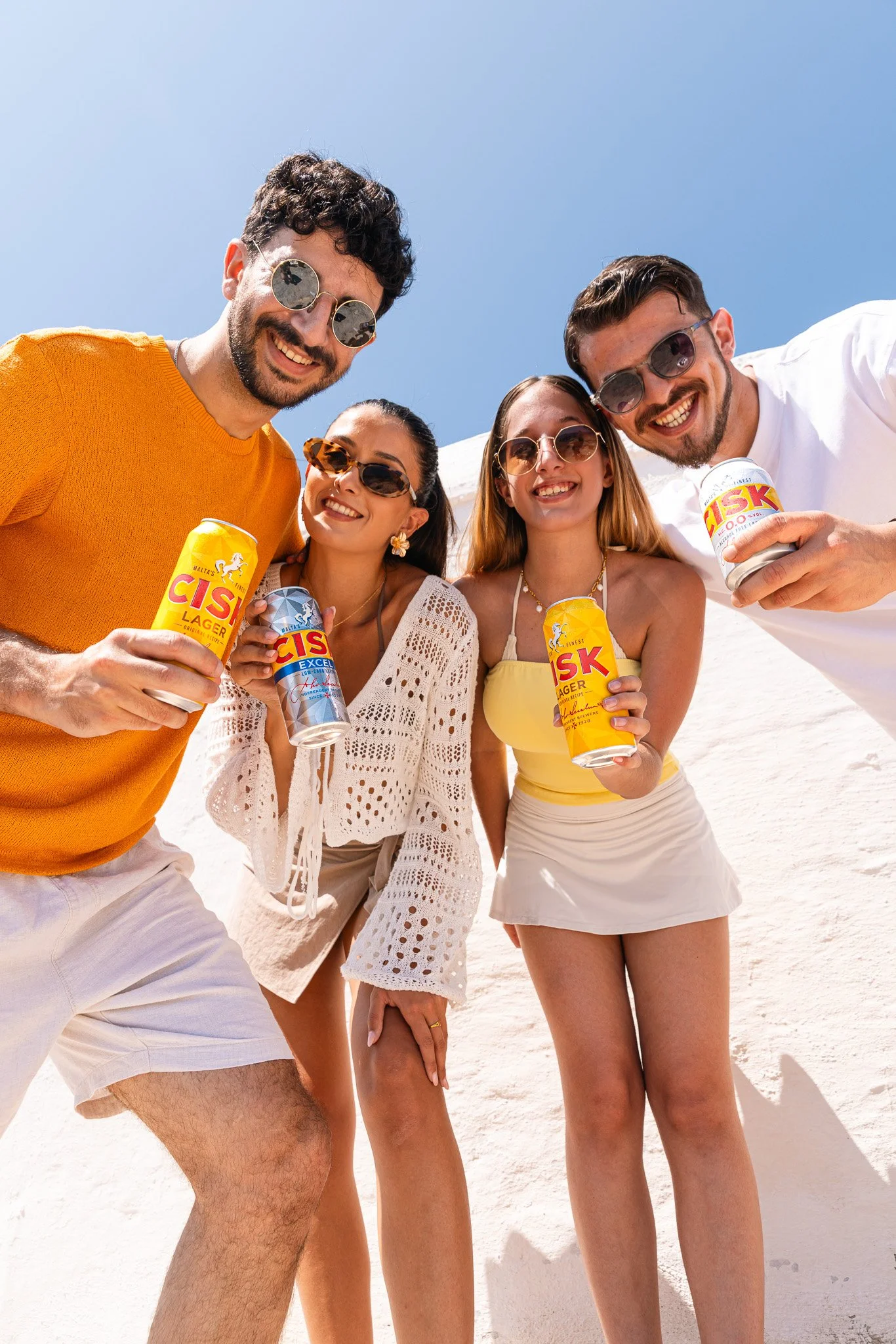 friends holding cisk lager and cisk excel cans, outdoors, summer photoshoot