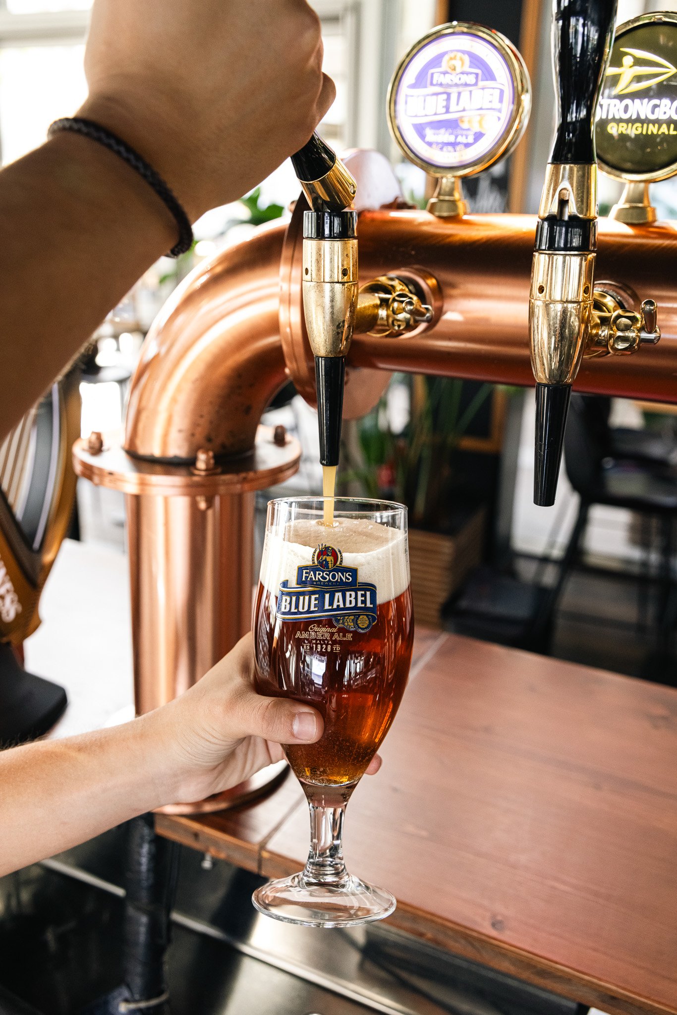 classic brews blue label being poured from draft, into glass