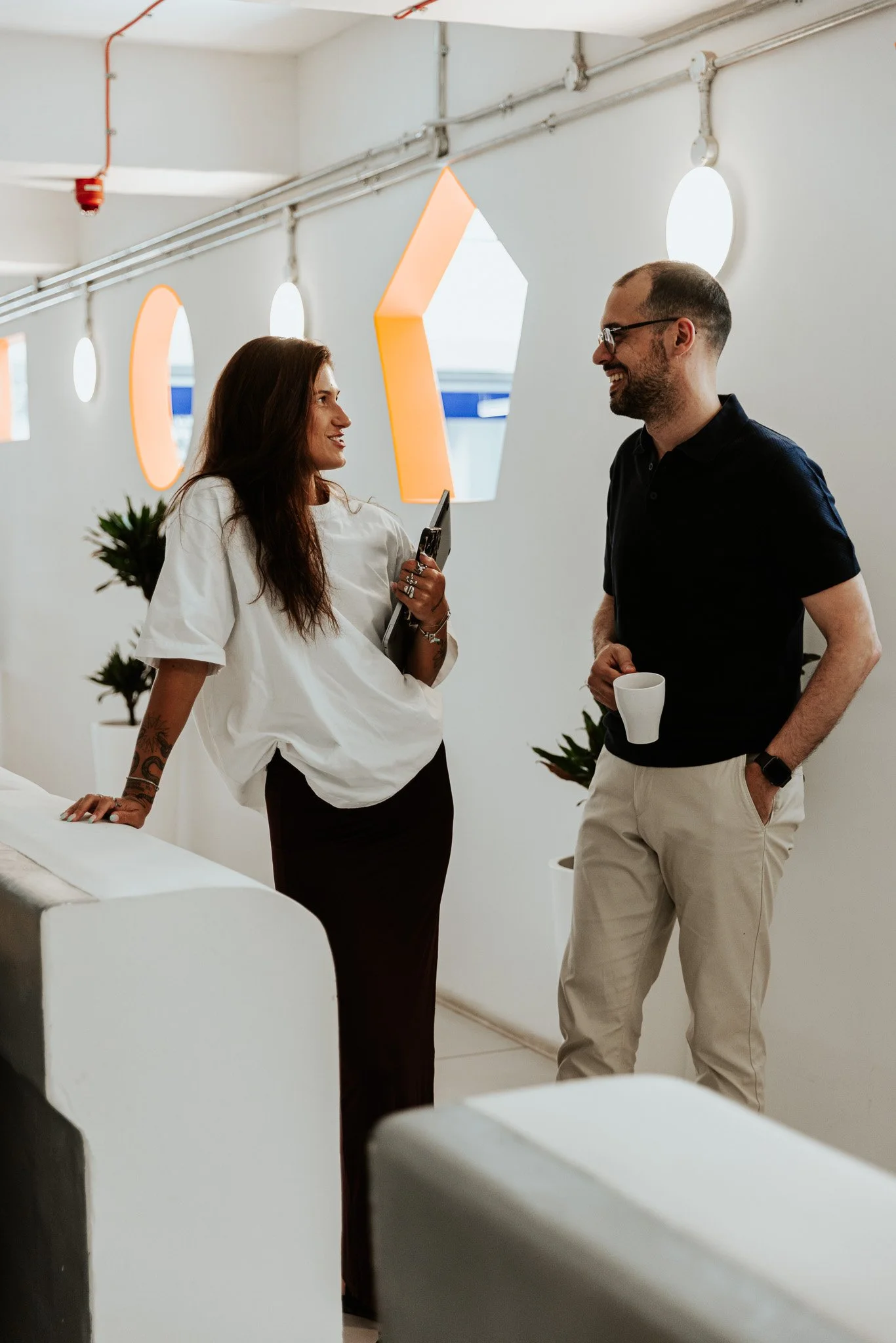 a man and a woman in the hallway of the vats coworking space, talking