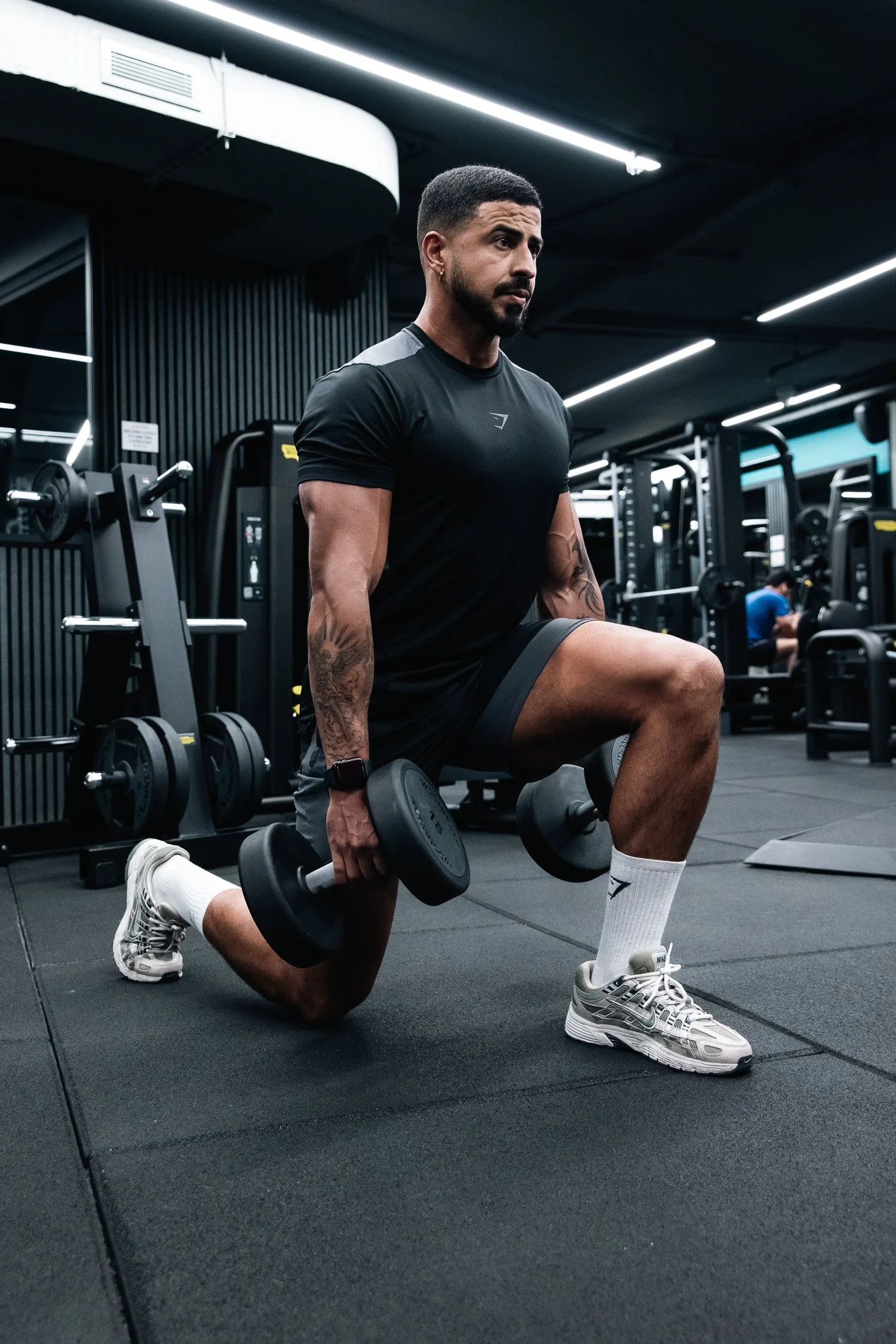 man doing lunges with weights, at the gym, trainer