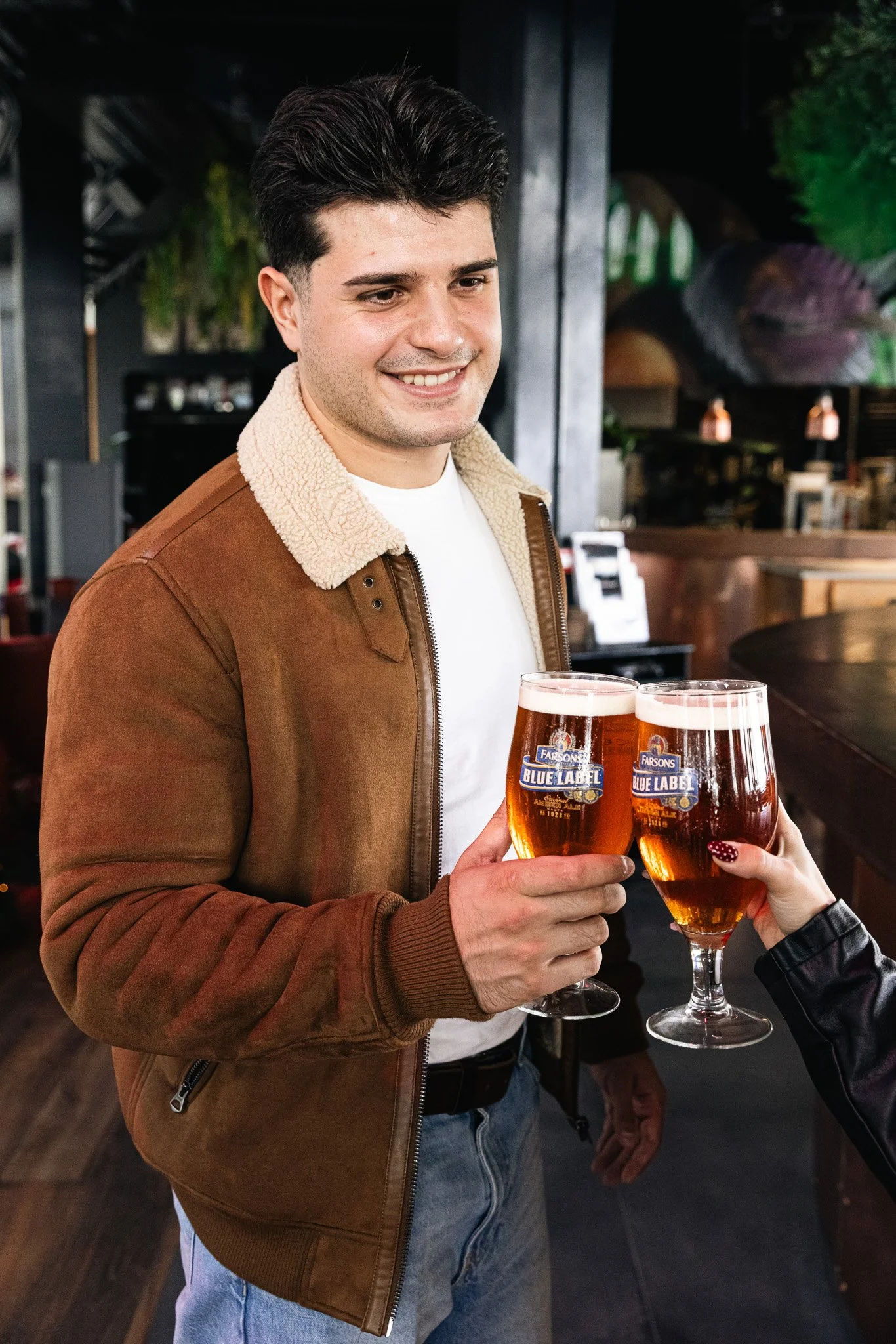 guy cheers with a friend, blue label classic brews, shoot