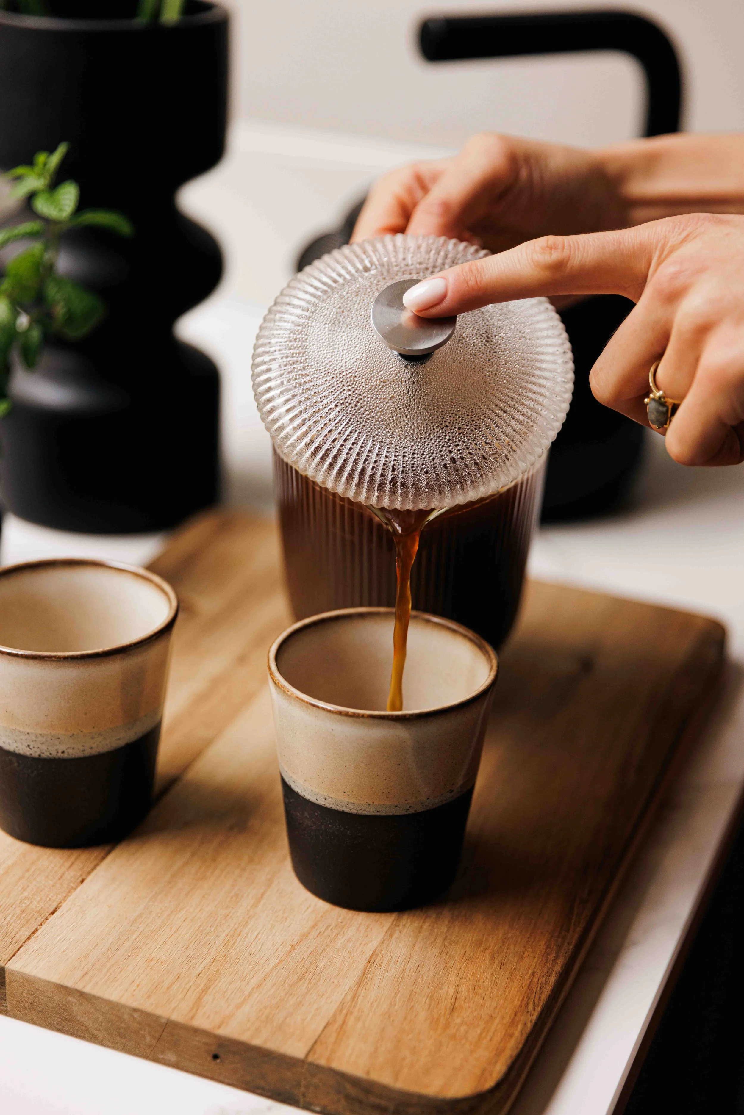 french pressed coffee being poured into an espresso mug