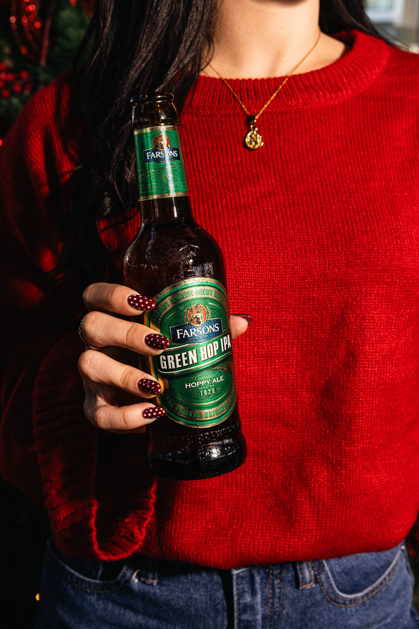 woman holding classic brews green hop ipa bottle in hand, winter christmas time shoot