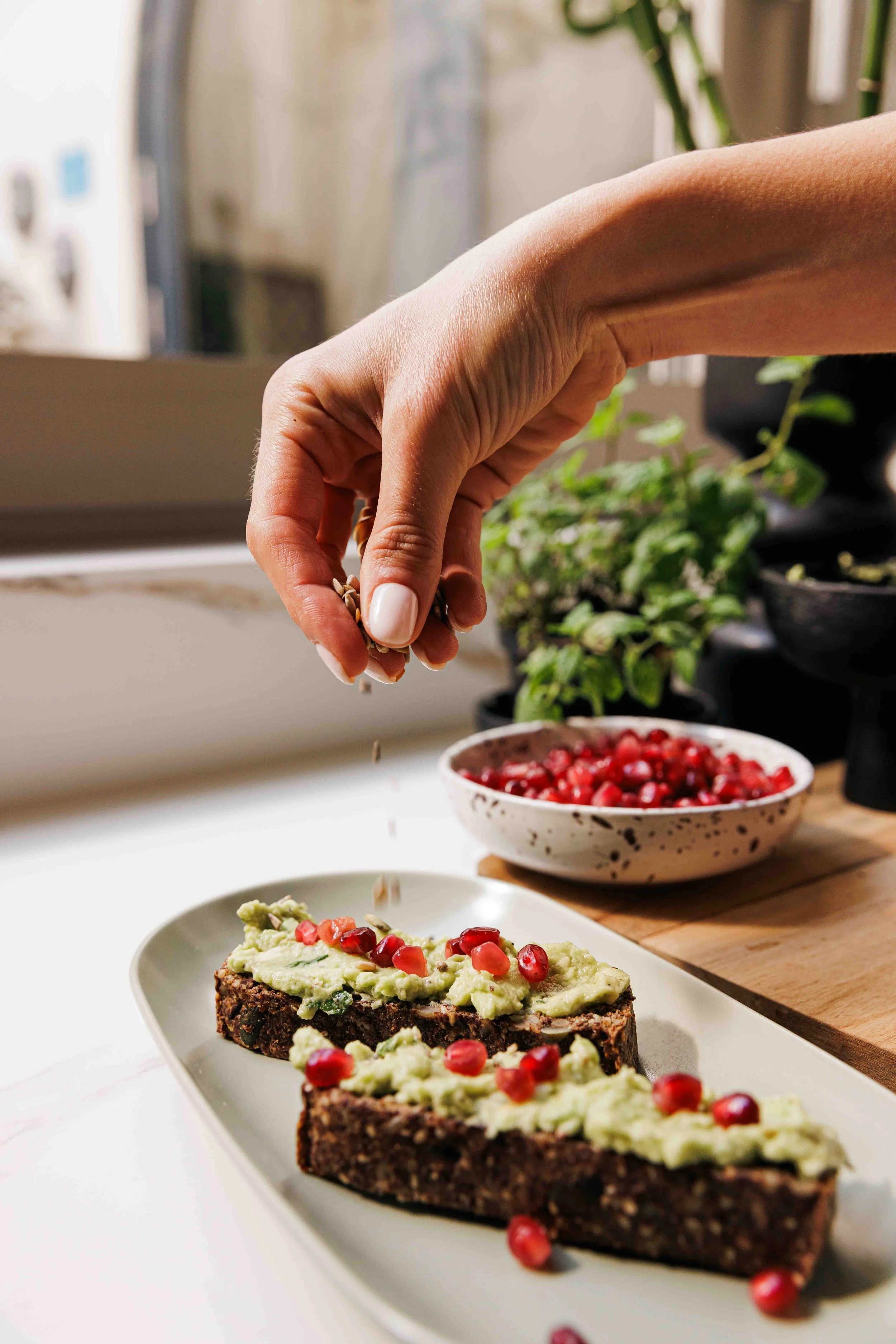 pomegranate being sprinkled on sourdough, photoshoot
