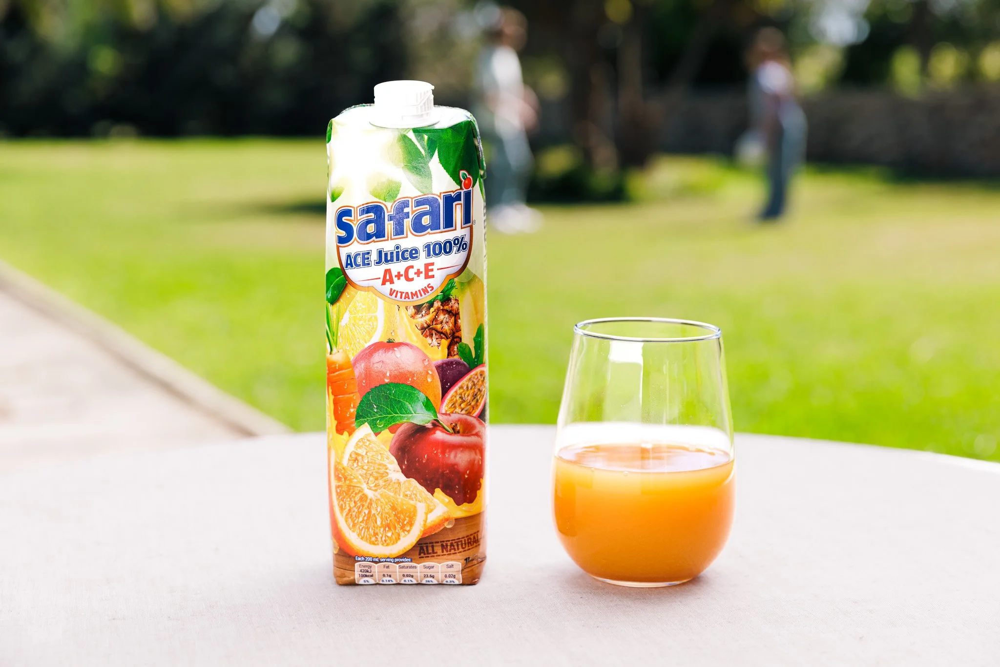 safari juice box, with glass, on a table, commercial shoot