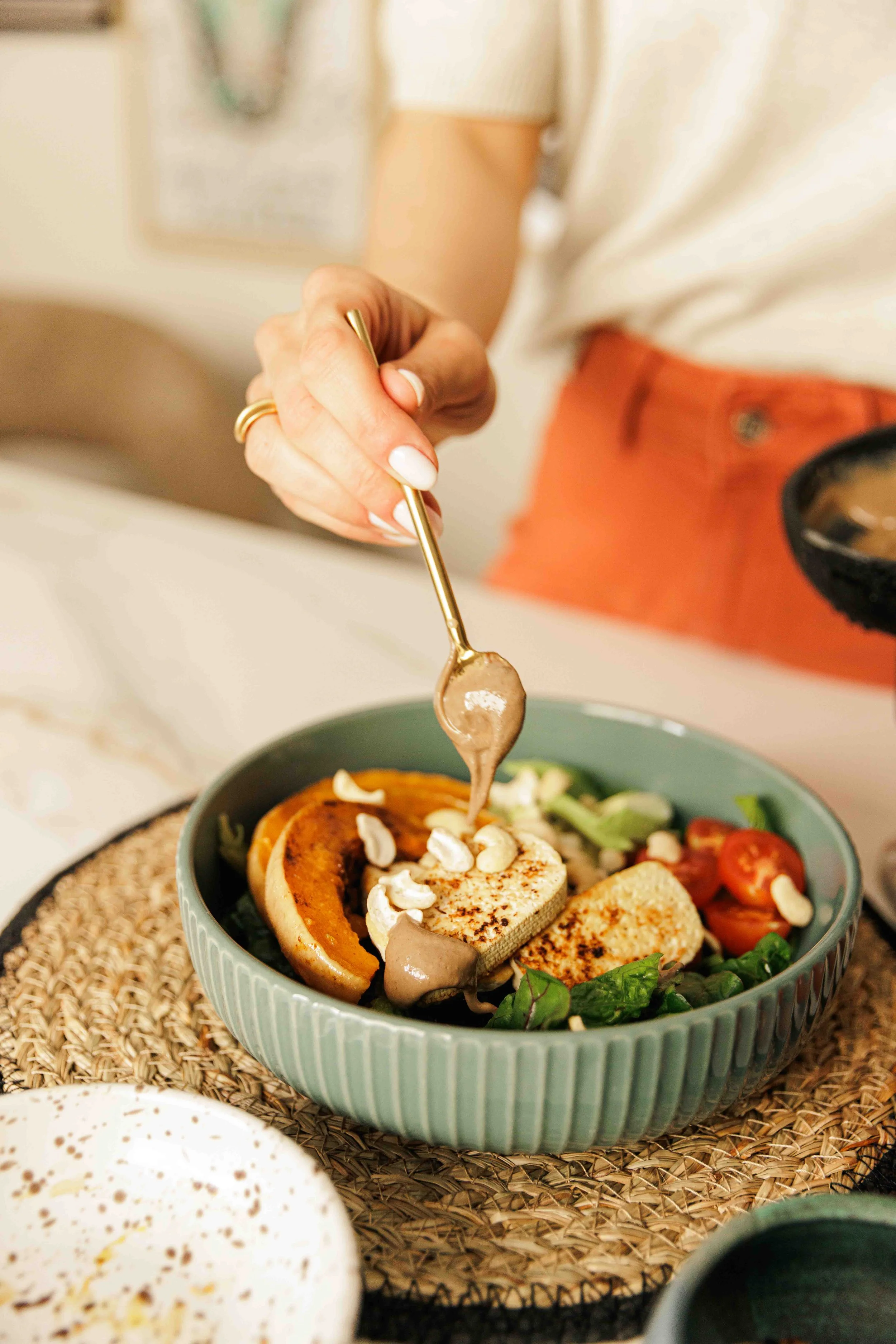 tahini sauce being drizzled on salad bowl, nutritionist shoot