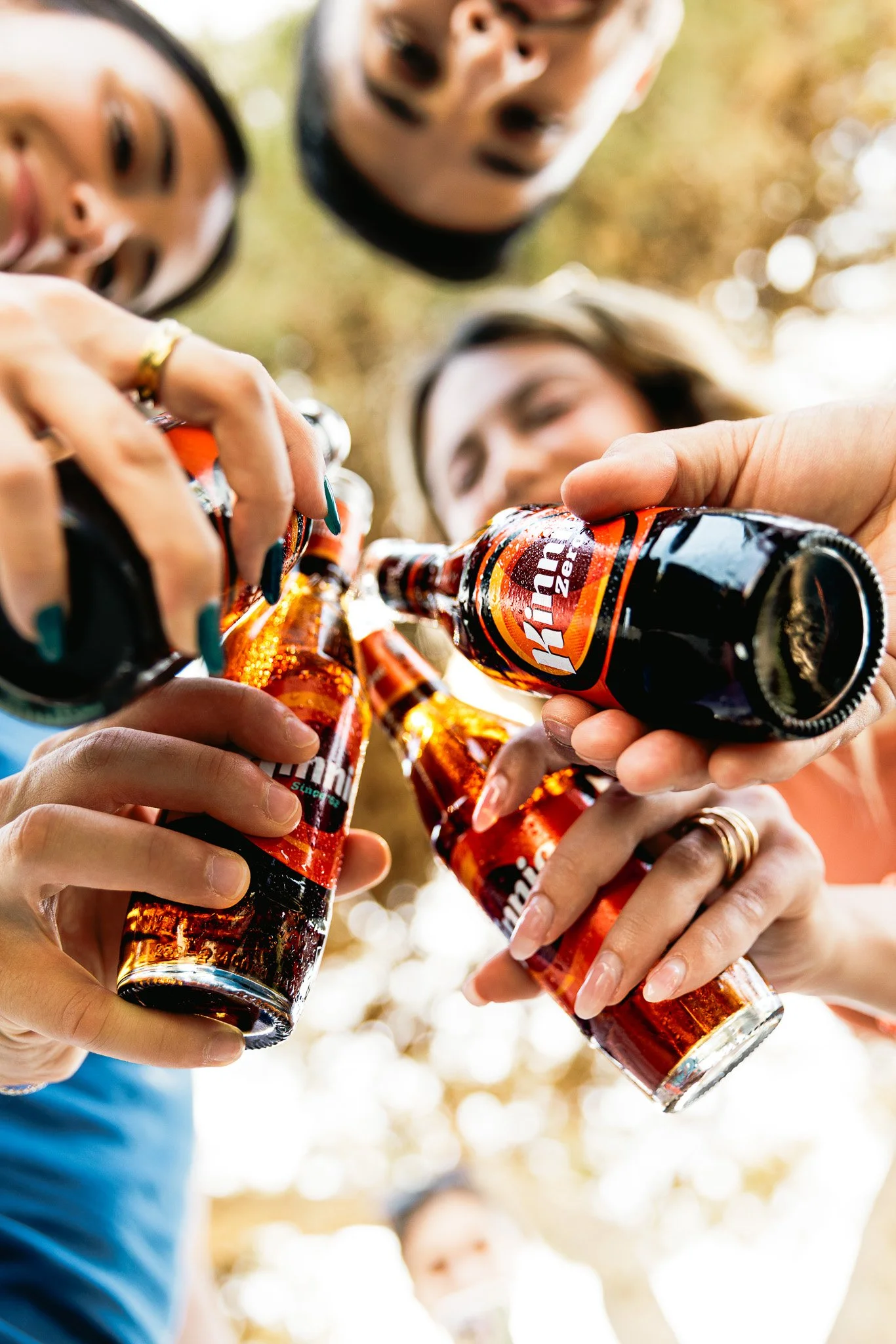 friends cheersing kinnie bottles