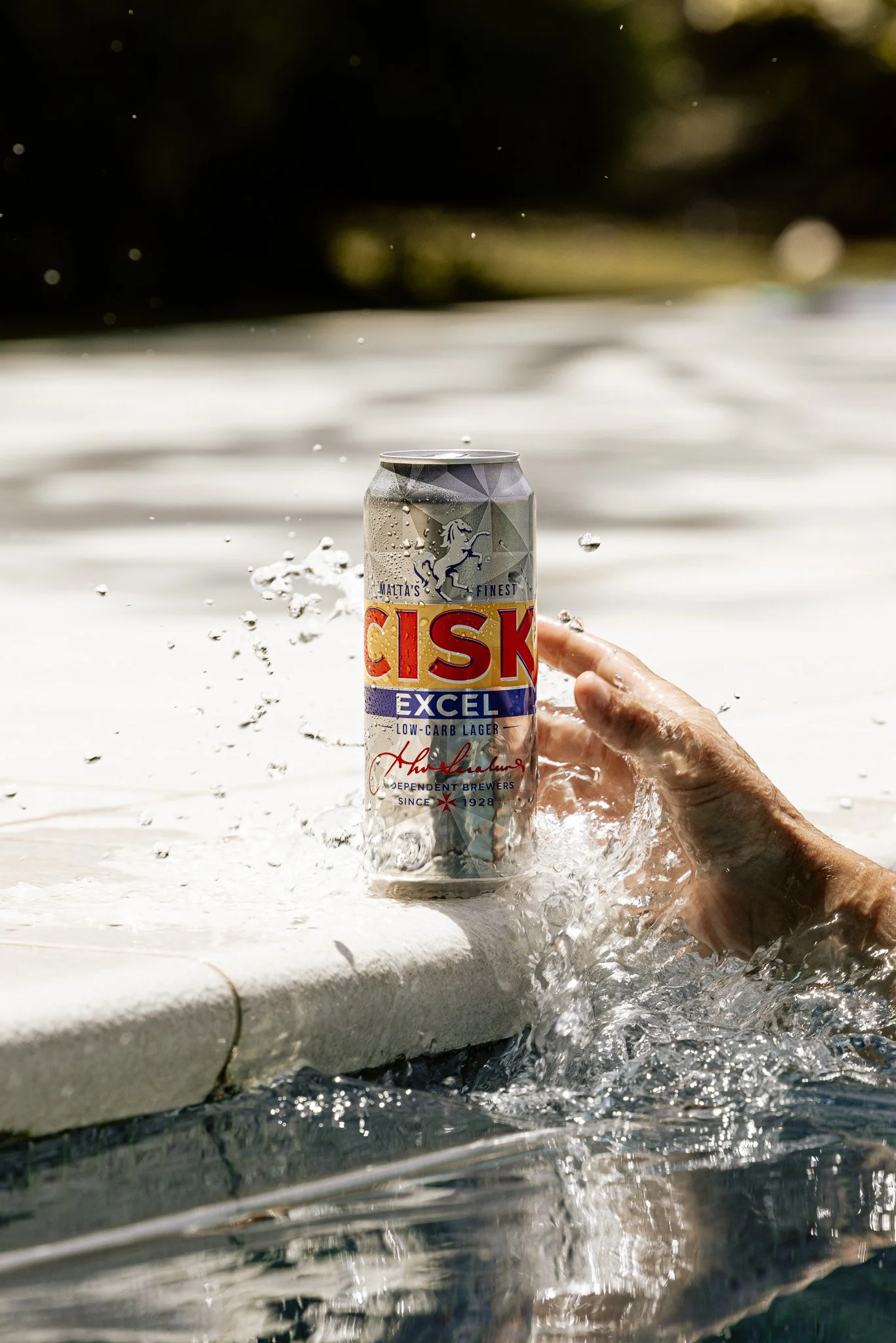 cisk excel beer can by the pool, water splash, product shoot