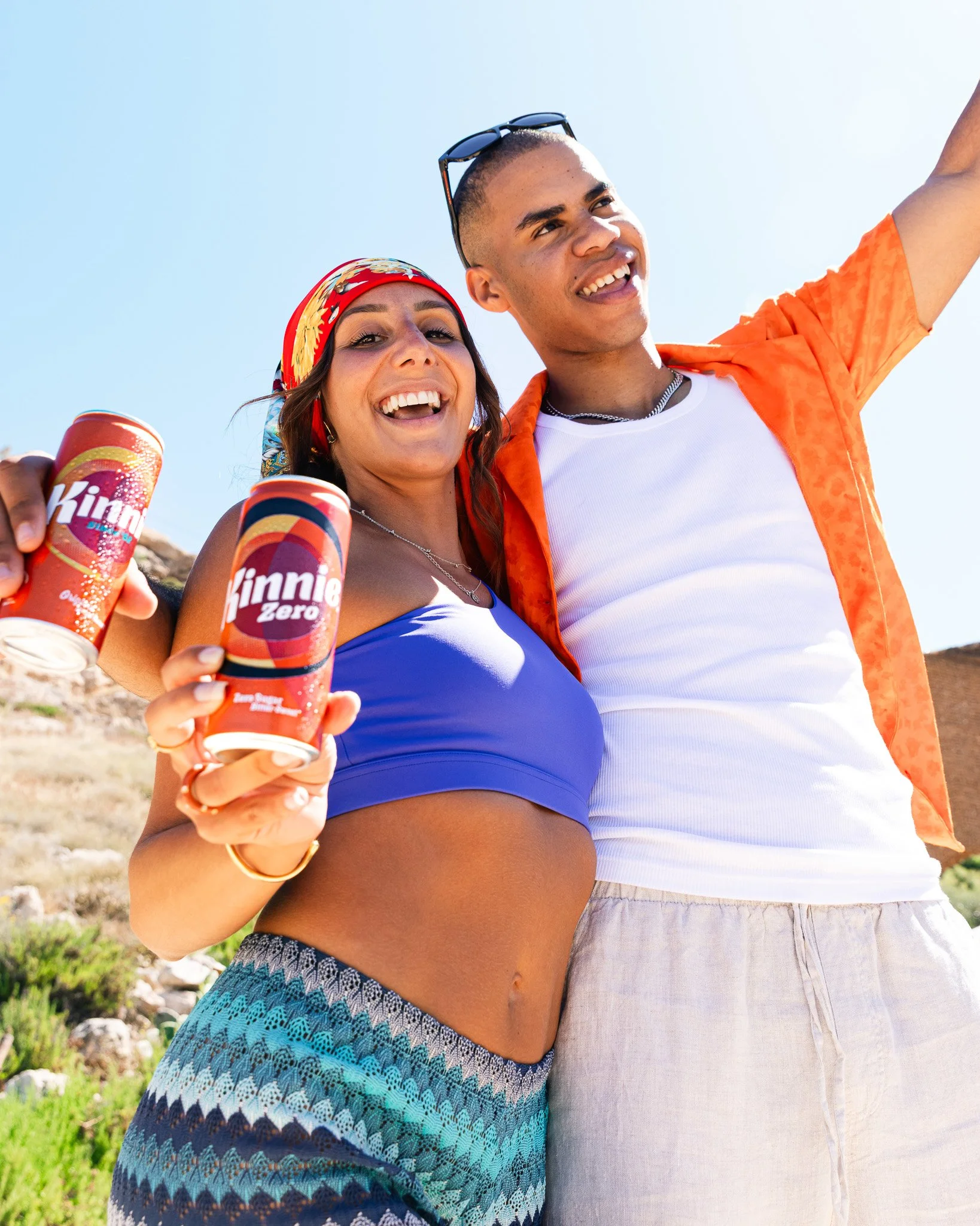 two friends having fun outdoors in summer, holding a kinnie can, summer shoot