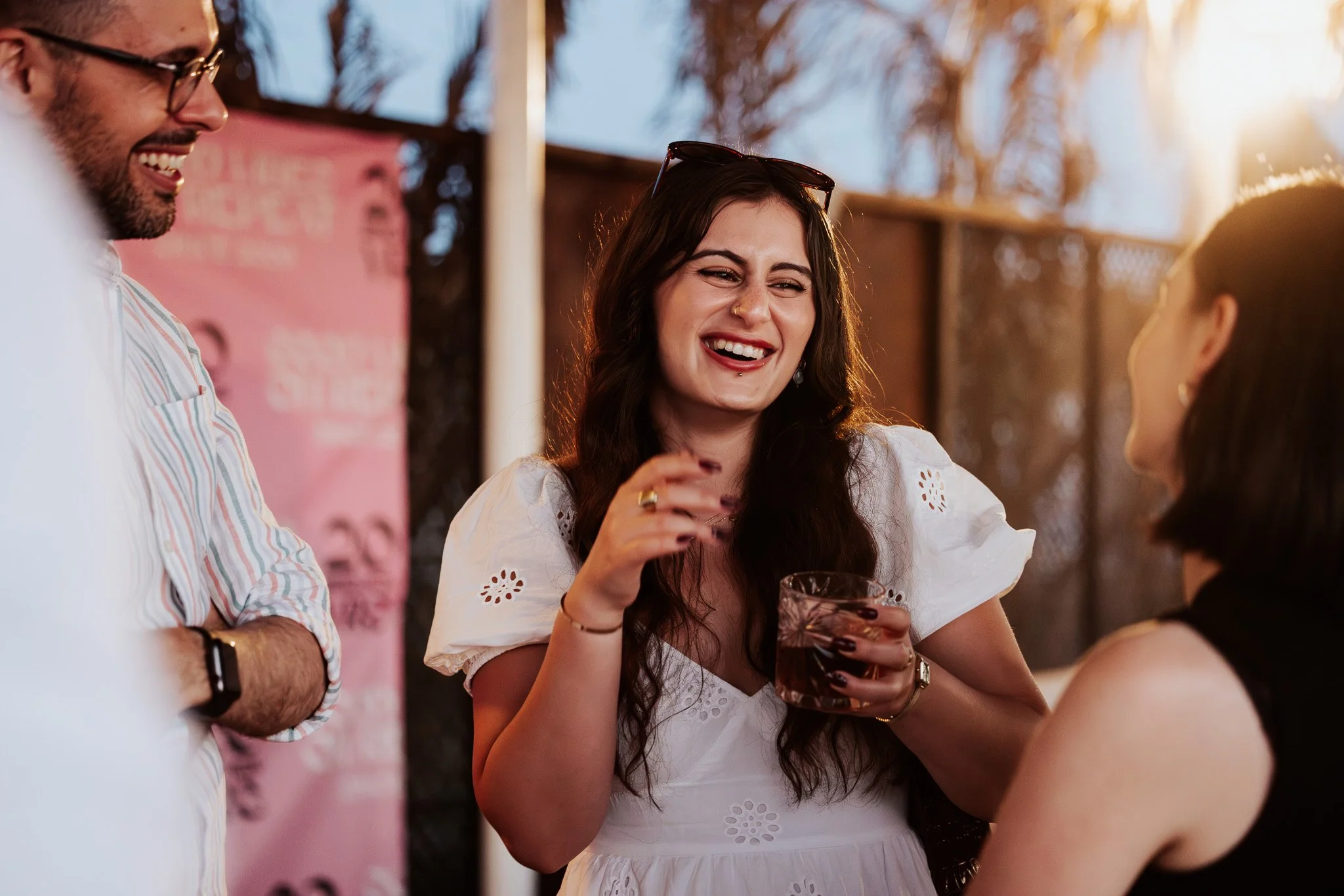 Woman laughing at a staff party event, summer, event photography.