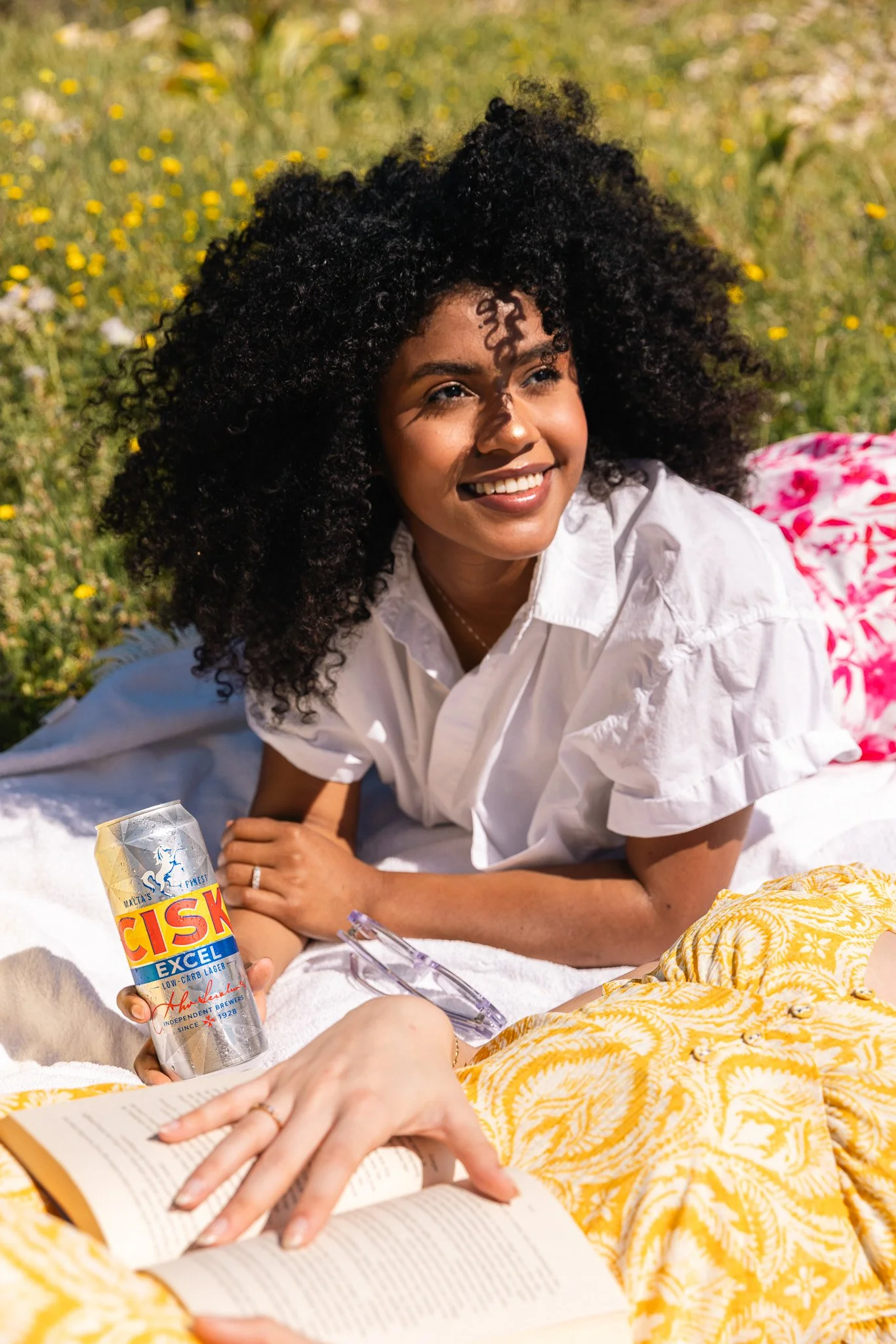 woman outdoors at a picnic, holding a cisk excel can