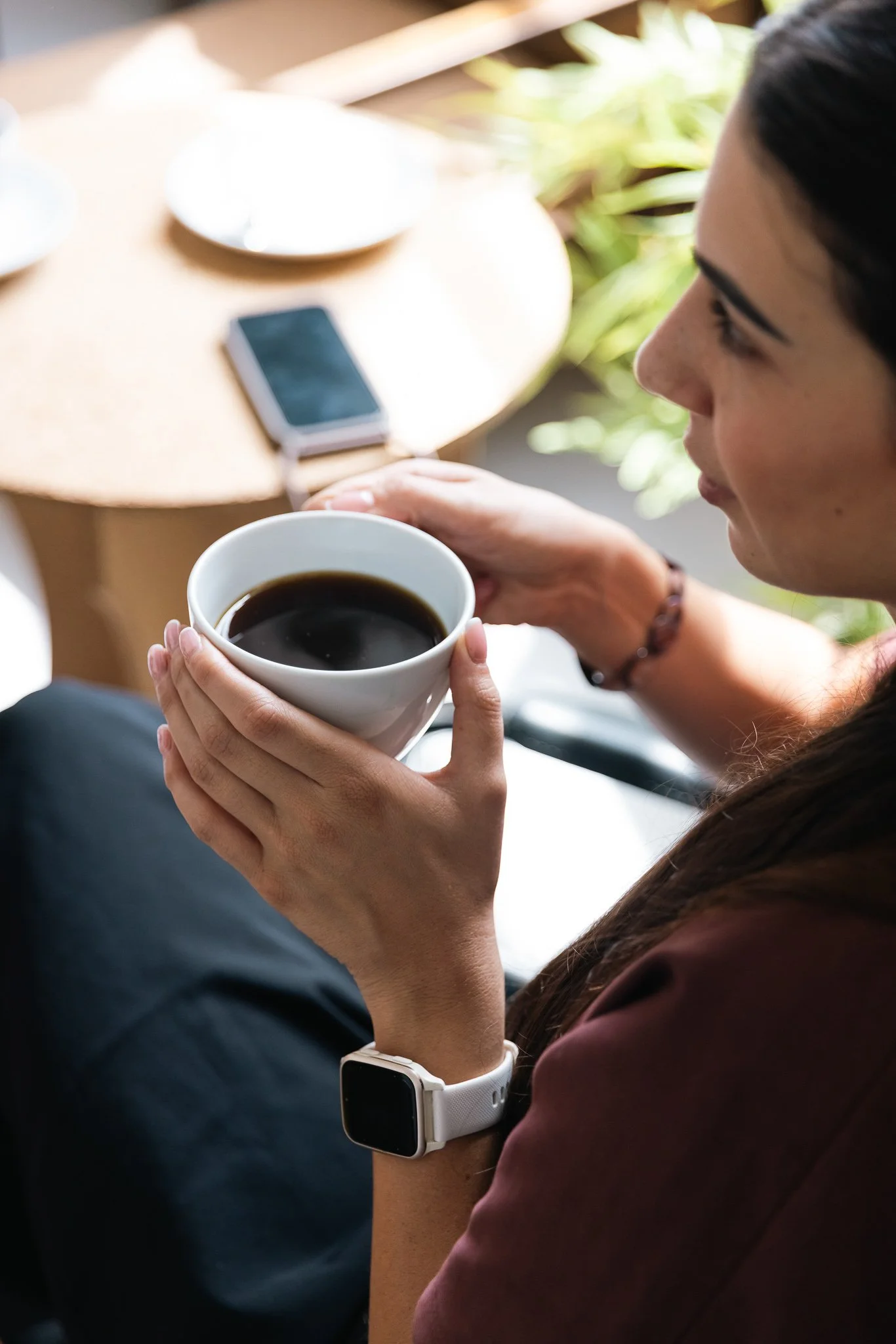 woman holding a cup of coffee in her hands, at the vats coworking space