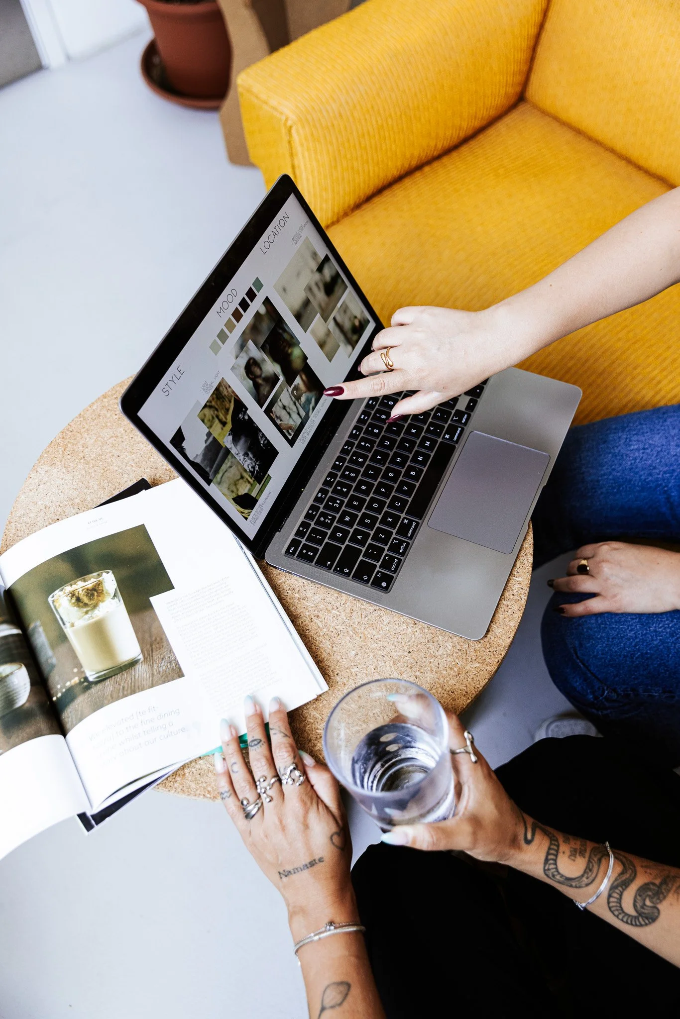 working at a laptop and with a book on a table, coworking space