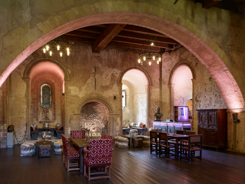 Interior of a historic building with arched ceilings, rustic decor, and antique furniture.