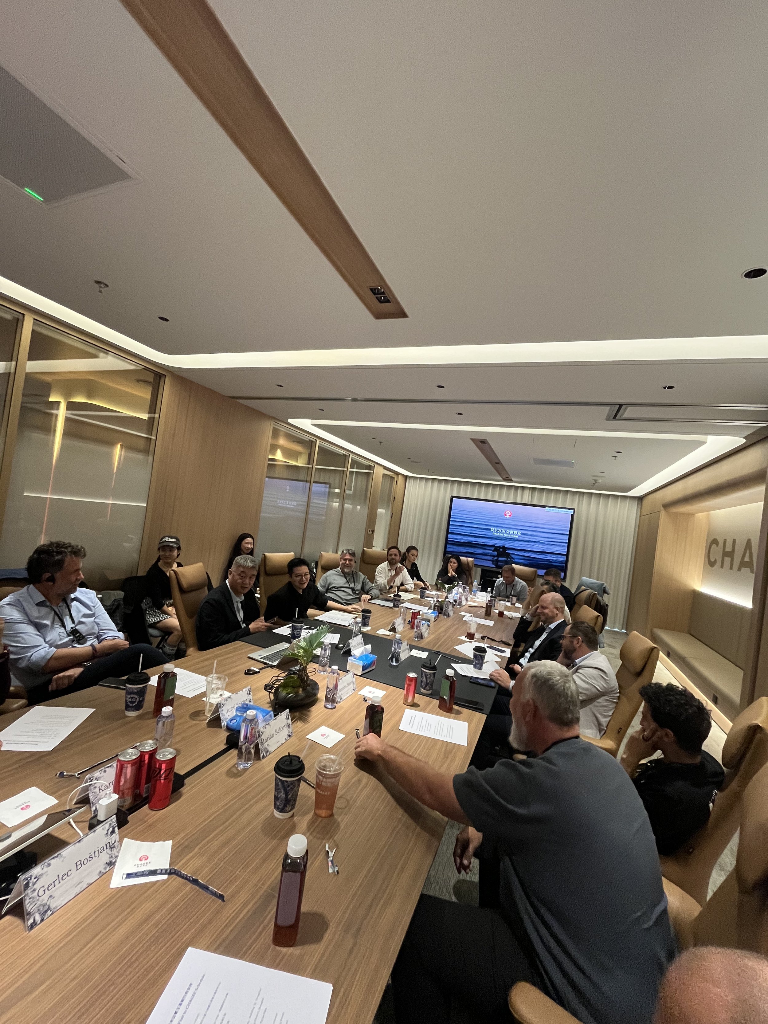 A group of  people sitting down, talking and listening to the presentation at GHAGEE in China during a business visit