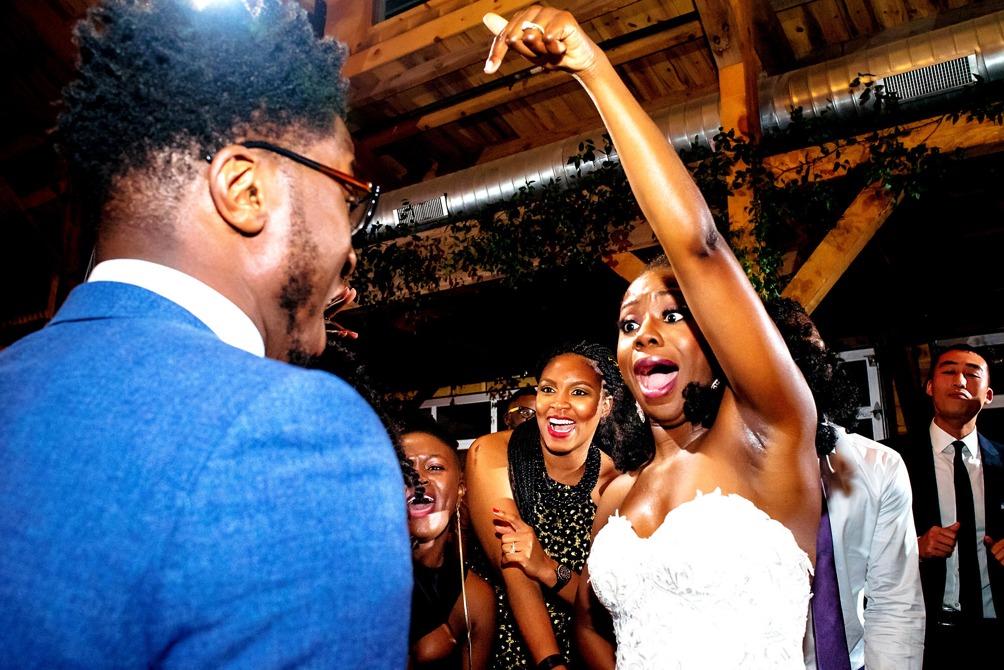 54-Austin-wedding-photographer-Jide-Alakija-bride jumping with hands pointed to guest.jpg.JPG