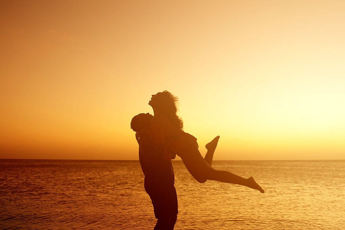 01-Aruba-wedding-photographer-Jide-Alakija-Boy lifts excited girl up on beach in aruba- engagment shoot.jpg.JPG