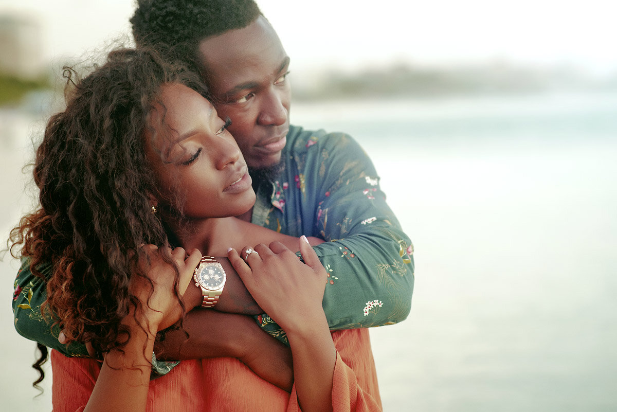 02-Aruba-wedding-photographer-Jide-Alakija-boy holding girl around shoulders looking into the sunset in aruba- engagment shoot.jpg.JPG