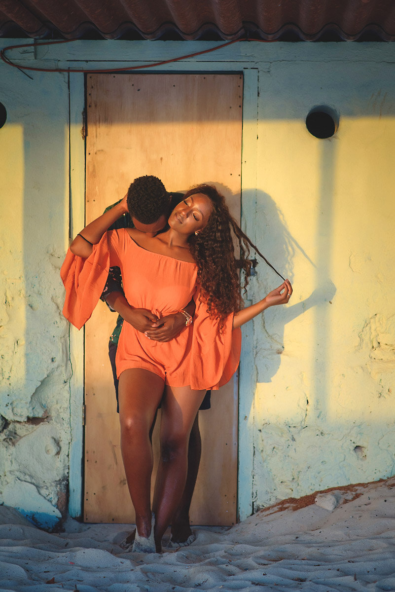 03-Aruba-wedding-photographer-Jide-Alakija-boy holding girl whilst leaning on wall in sunset- engagment shoot.jpg.JPG