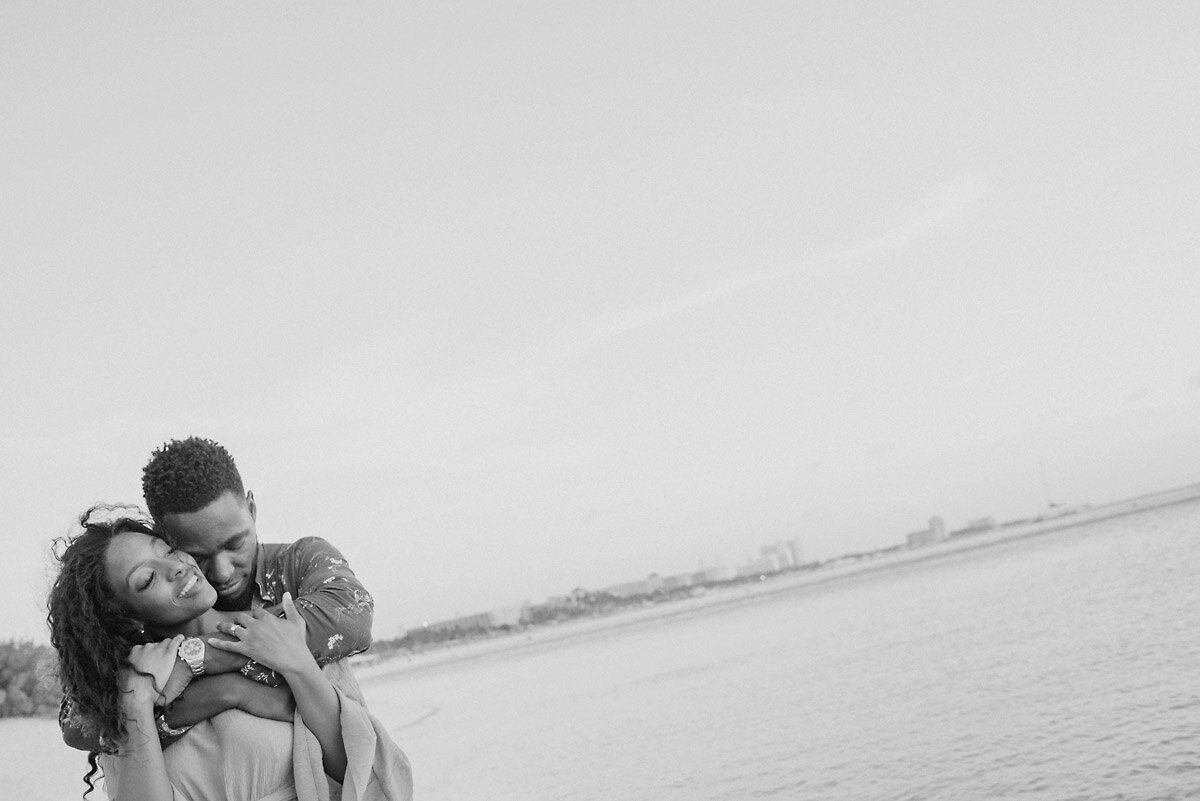 09-Aruba-wedding-photographer-Jide-Alakija-black and white photo of boy holding girl around shoulders and snuggling in aruba- engagment shoot.jpg.JPG
