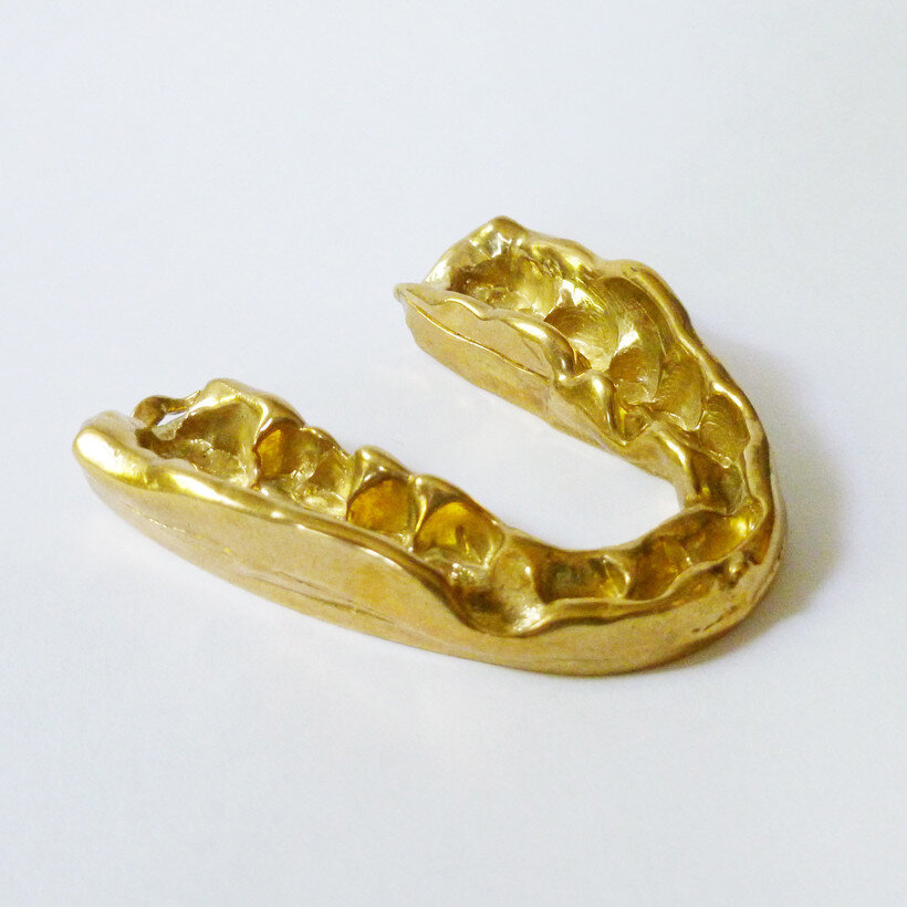 Carolyn Salas, "Grinder Necklace,” 2013, cast brass, platted gold, 3"x 3" on 14 karat gold chain (length can vary)