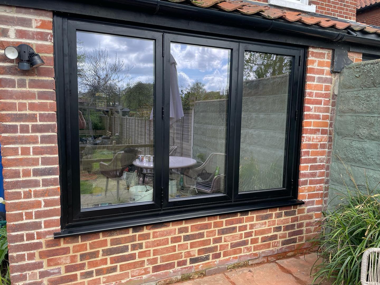 Replacing an old UPVC patio door with an aluminium bi folding window and bricking up 6 courses of Norfolk reds below.Replace an old UPVC window and reinstate an aluminium slimline door all in Black. #bespokedoubleglazing #aluk #buildingworks #iceniwi