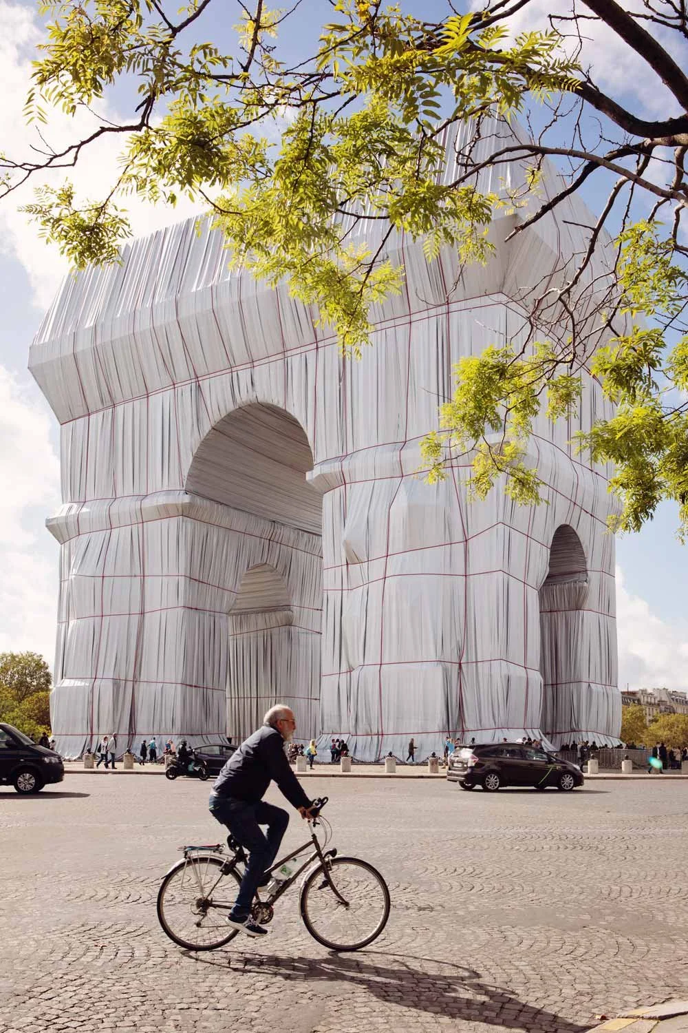 fietser voor de Arc de Triomphe de zon schijnt