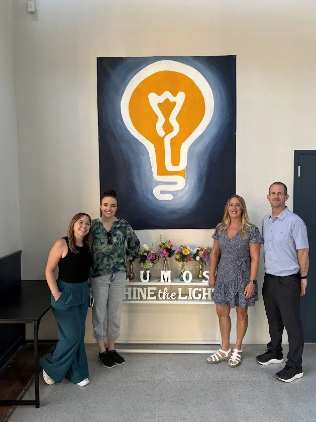 The Lumos team in front of the painted lightbulb mural in the lobby