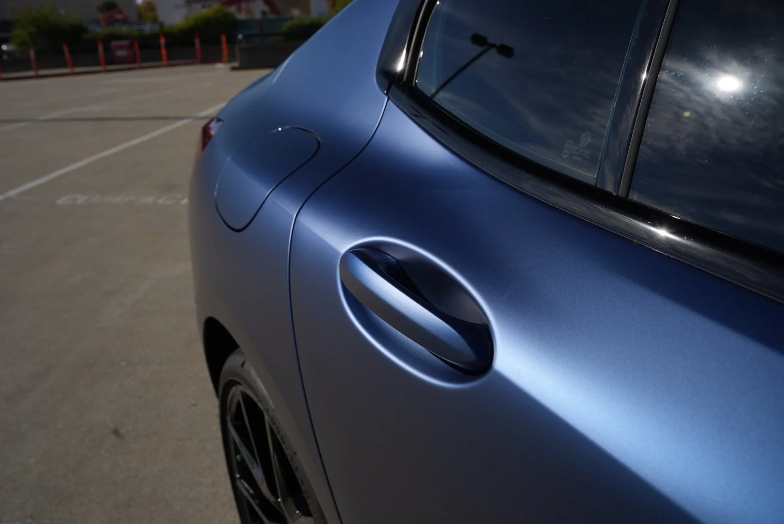 Close-up of a metallic blue car's rear side, car wrap