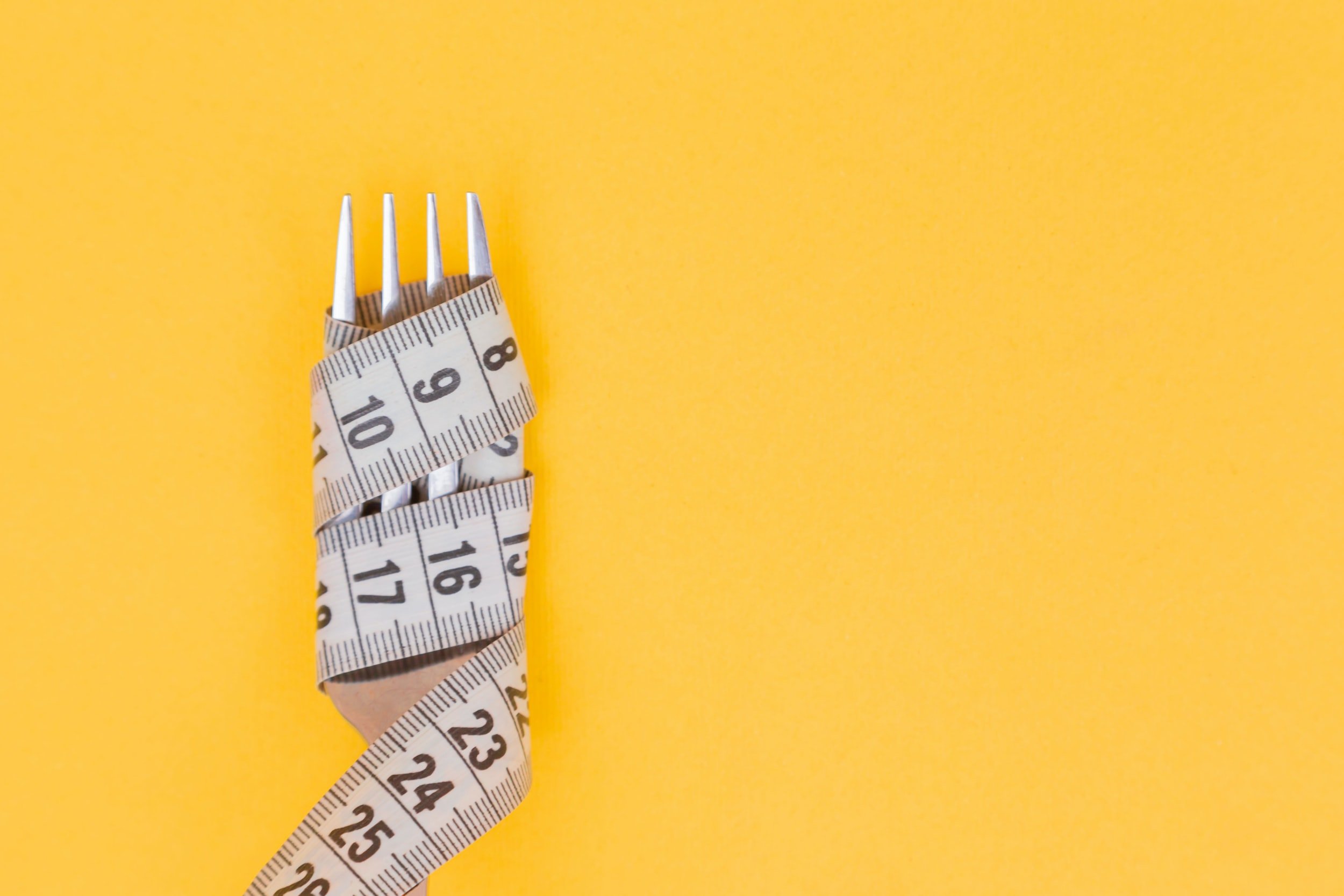 a fork with measuring tape around it
