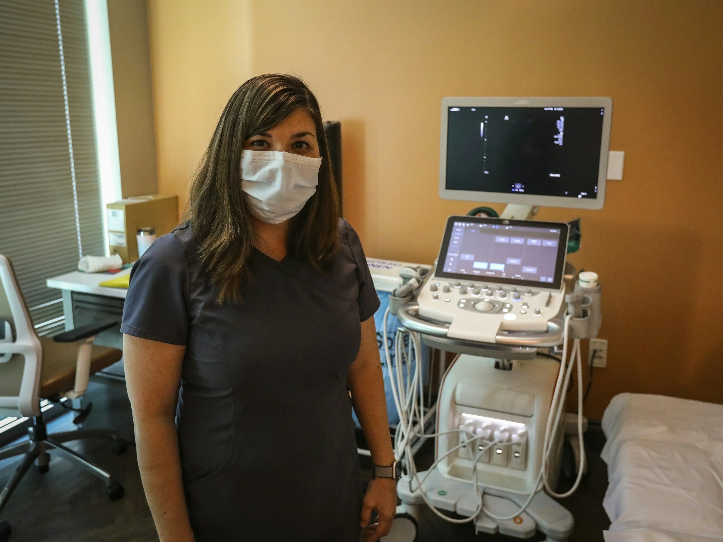 a nurse standing in front of an ultrasound machine