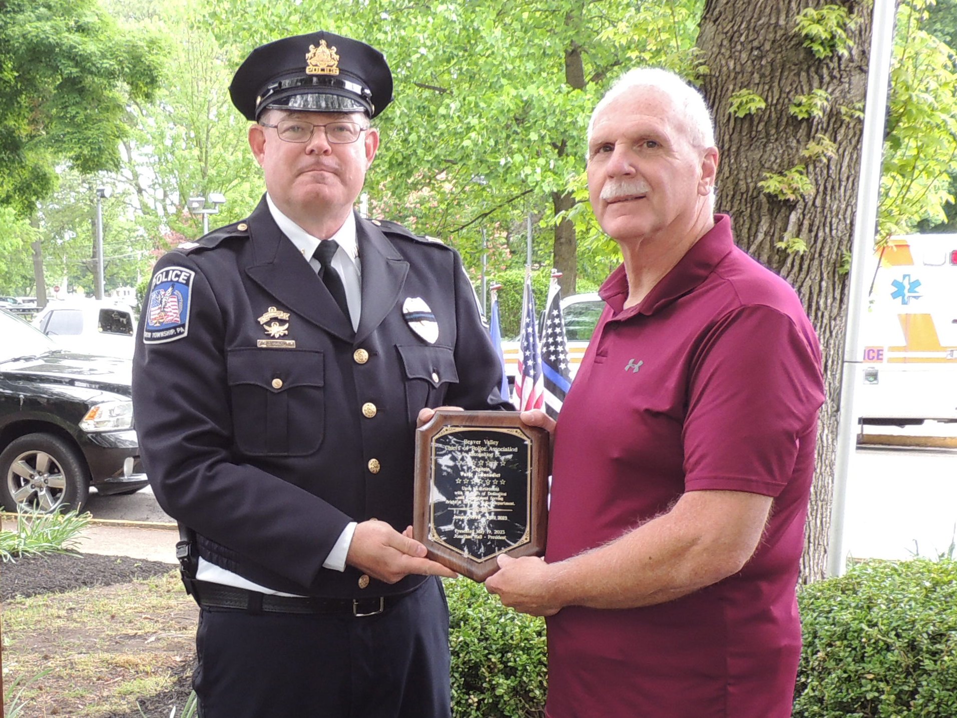 Captain Jonathan Hall presents a retirement plaque to Captain Peter J. Benedict for his 27 years of service to Brighton Township Police Department.