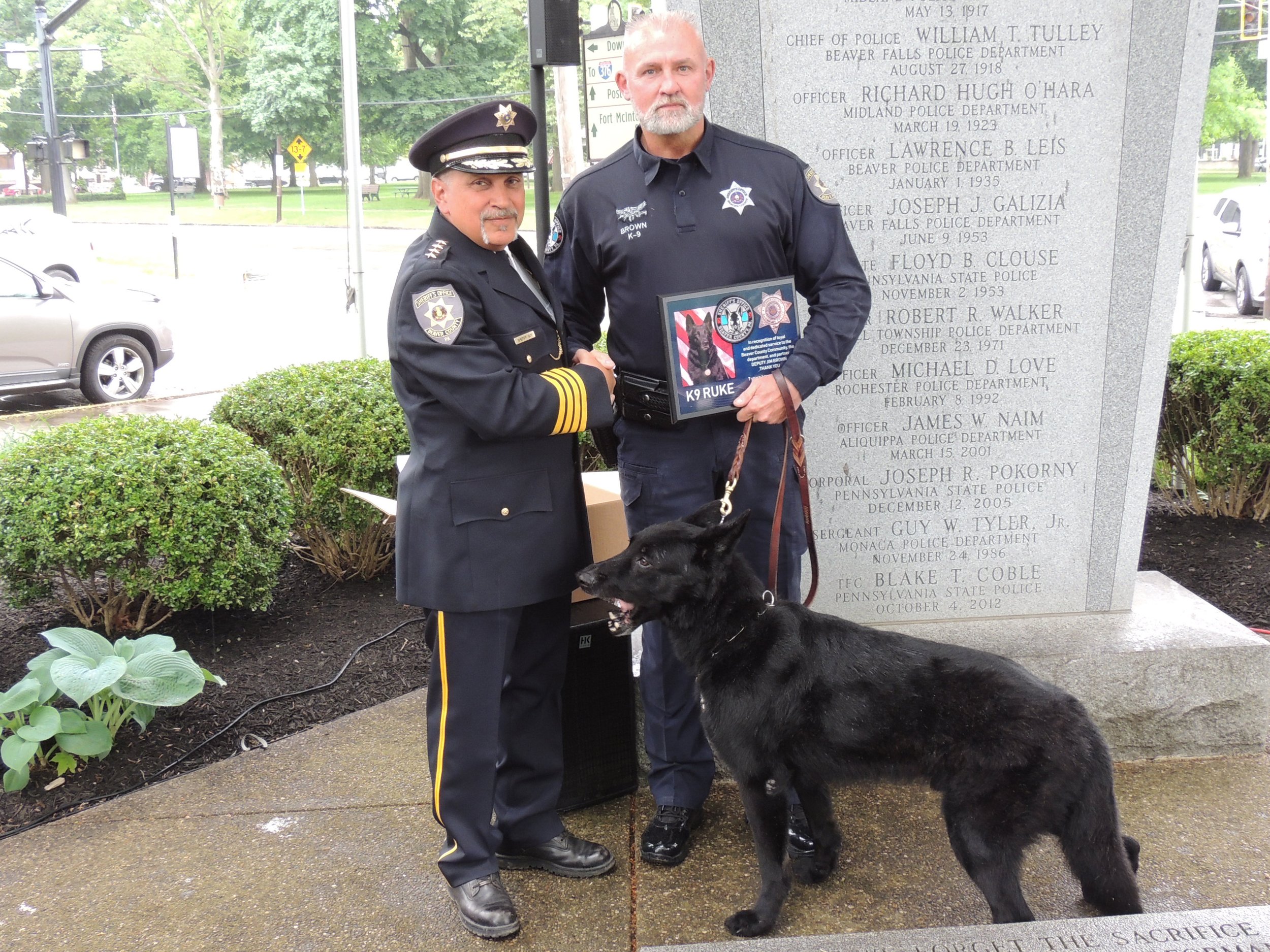 Sheriff Tony Guy presents K9 Officer Ruke with a retirement plaque for his loyal and dedicated service to his community and partner Deputy Jim Brown.