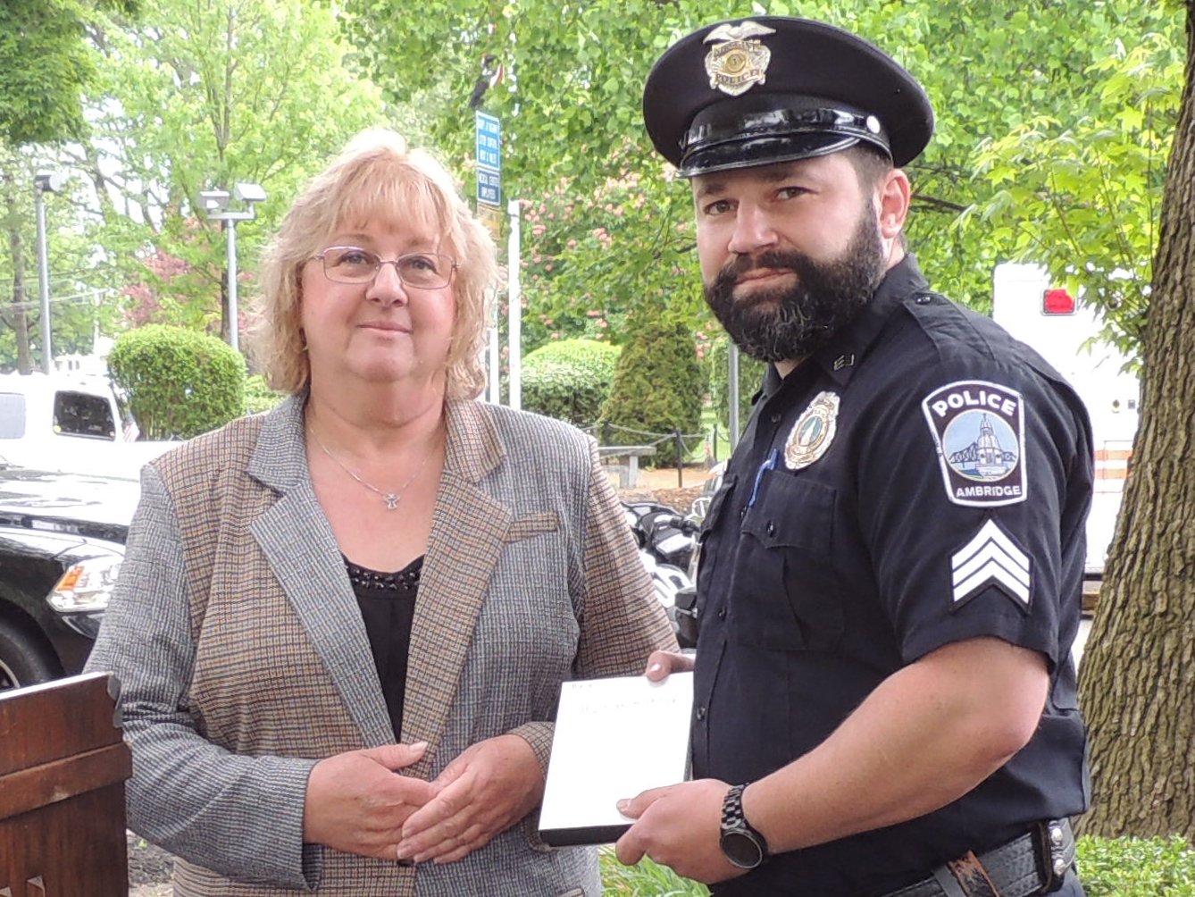 Advocacy Coordinator Millie Anderson presents an award for exemplary service in handling domestic violence cases to Officer A.J. Bialik (Ambridge Police Department).
