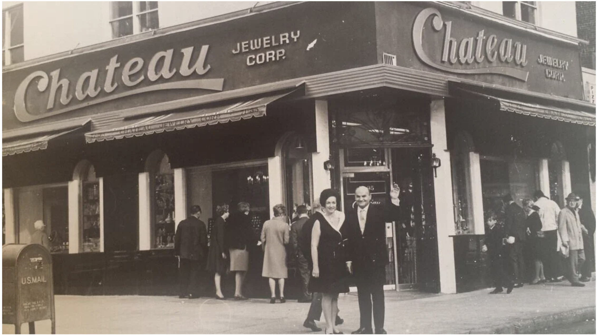 Black and white photo of a jewelry store named Chateau Jewelry Corp. with a crowd of people outside, including a smiling woman in a dark dress and a smiling man in a suit, on a city street. Vintage photo of grand opening in 1968