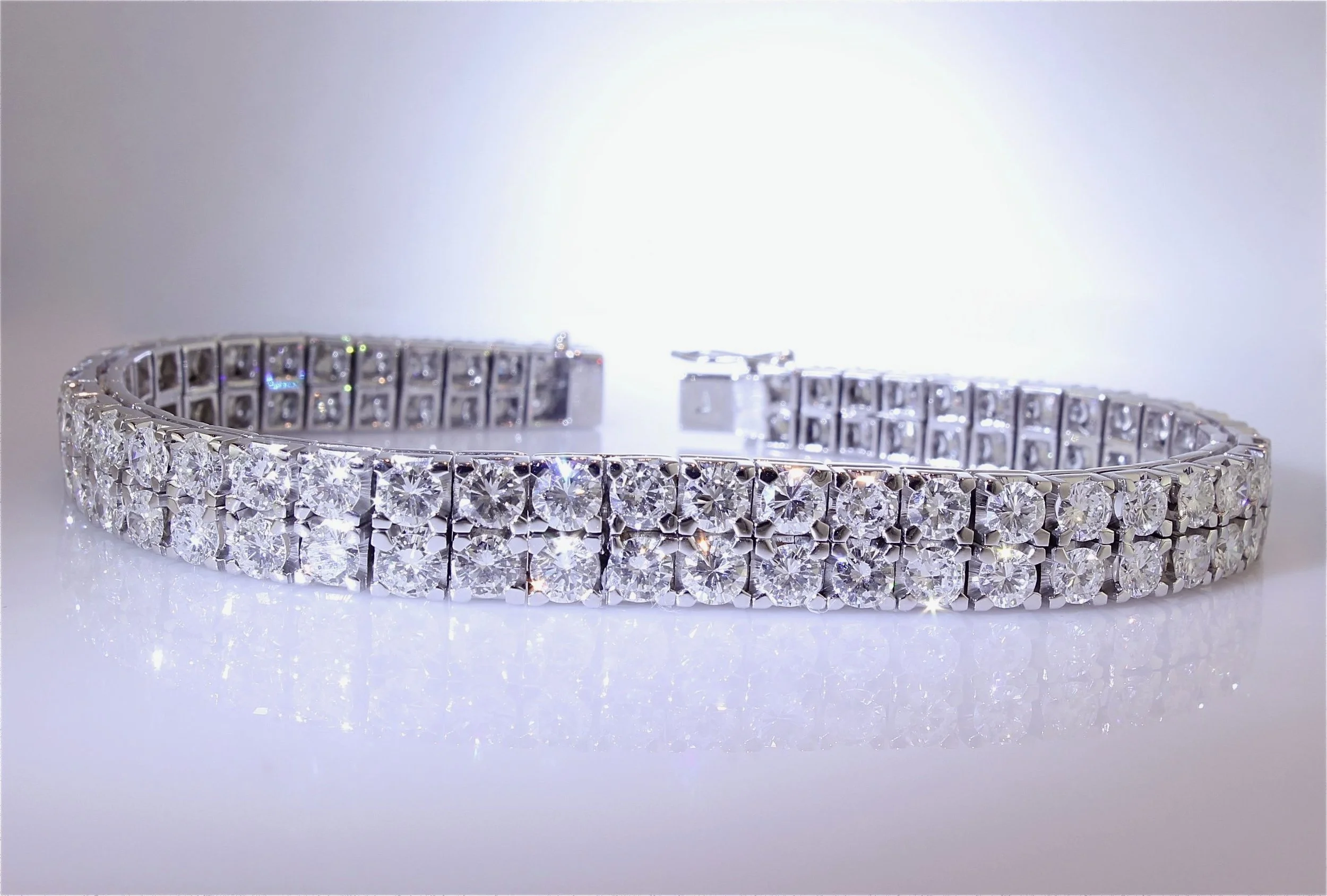 Close-up of a diamond tennis bracelet with large sparkling clear diamonds on a white background.