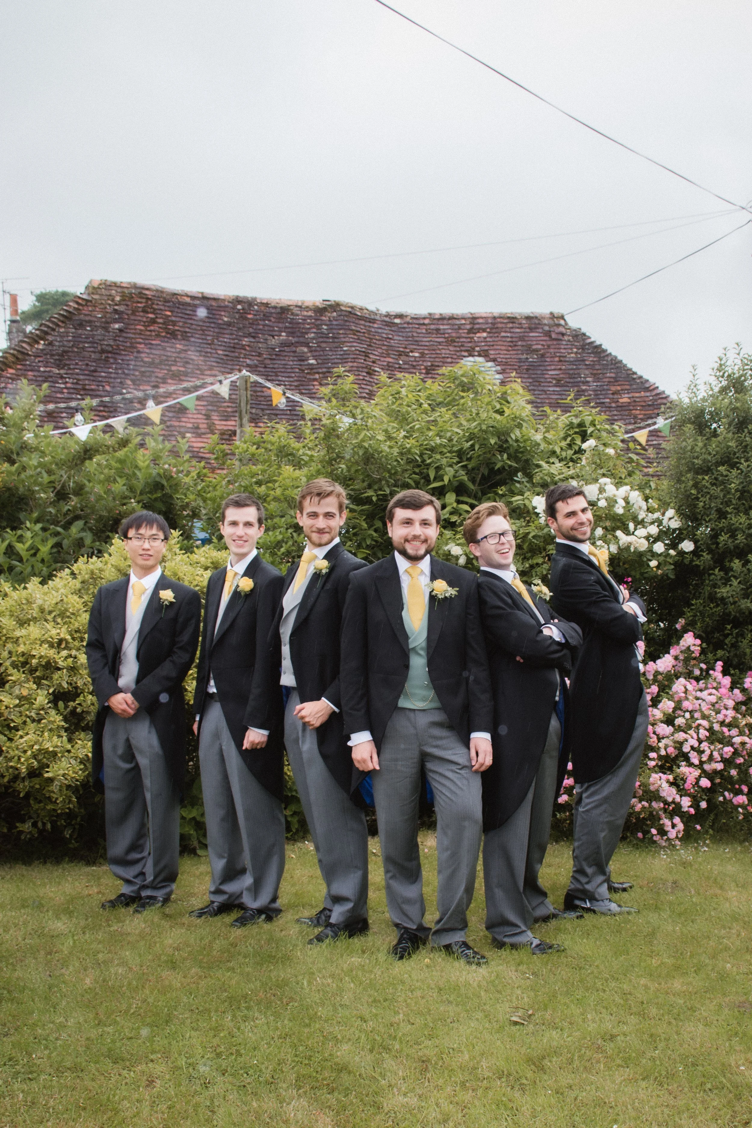 Groom and groomsmen standing together in the garden