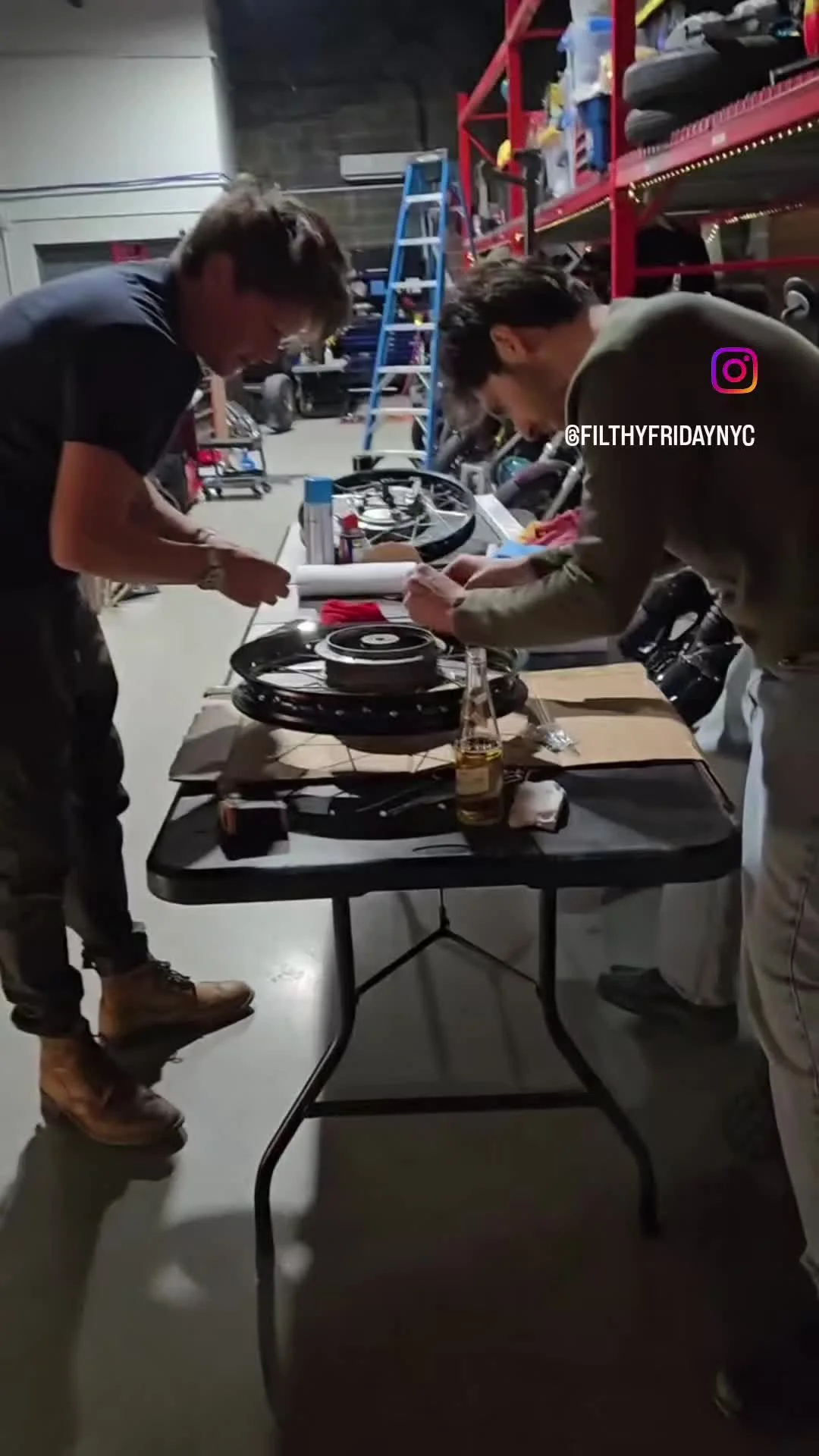 Members working together on a motorcycle wheel during Filthy Friday.