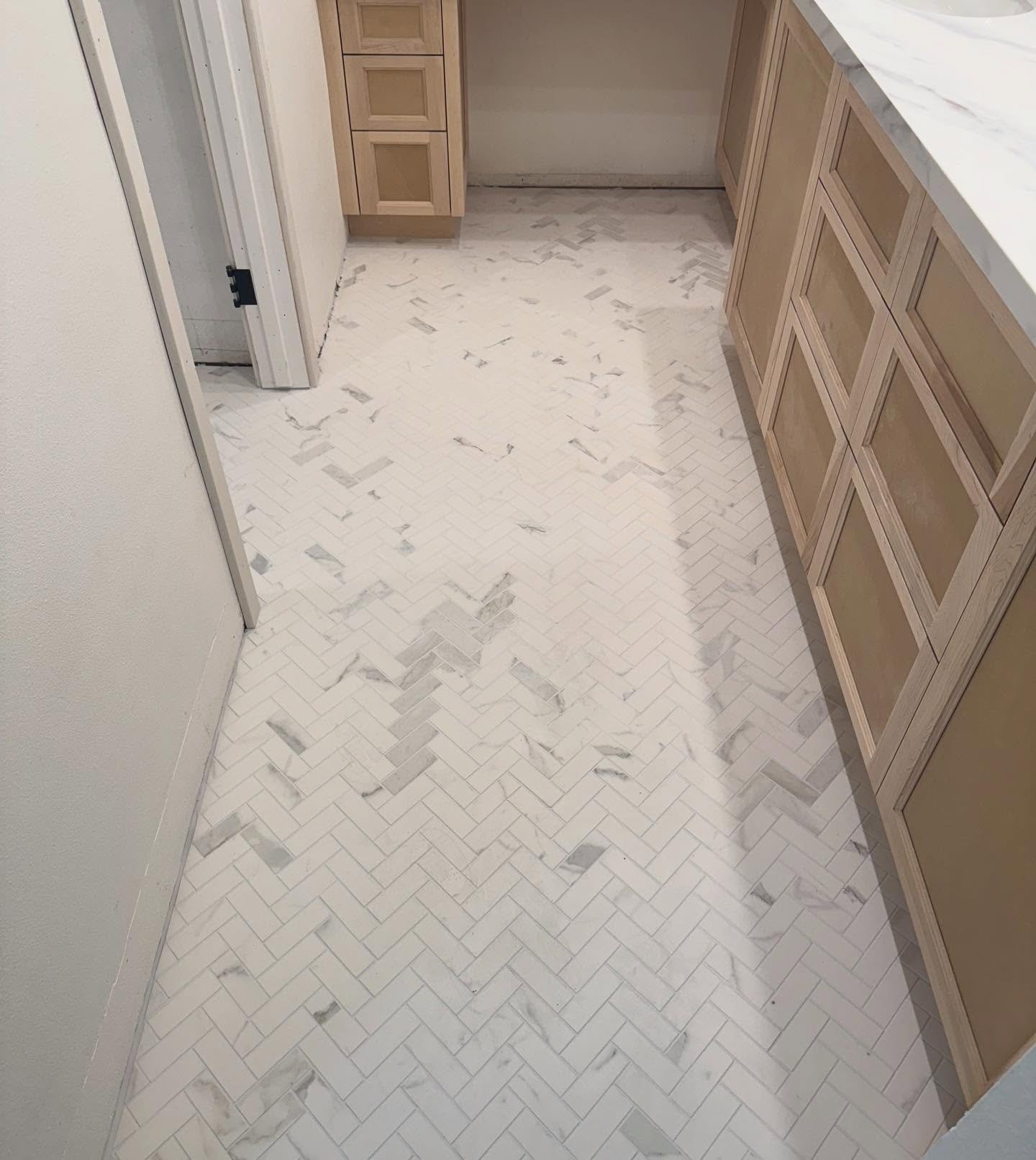 Cabinets are installed and the chevron flooring is everything ✨ #bathremodel #chevronflooring