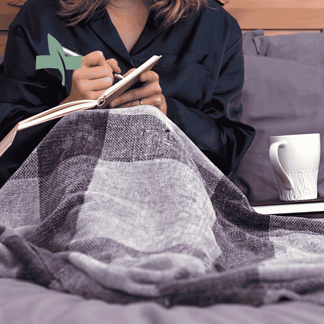 Woman journaling on a couch, illustrating the concept of tracking symptoms for improved healthcare engagement.