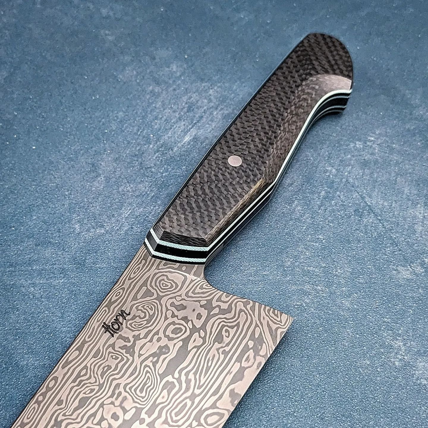 This puppy is pretty slick. Carbon fiber with Tiffany Blue liners. The blade is a forged Fenja pattern from @damasteelab and it turned out way better than I was expecting. The shape is actually a bit different than my usual gyuto. This took a tiny up