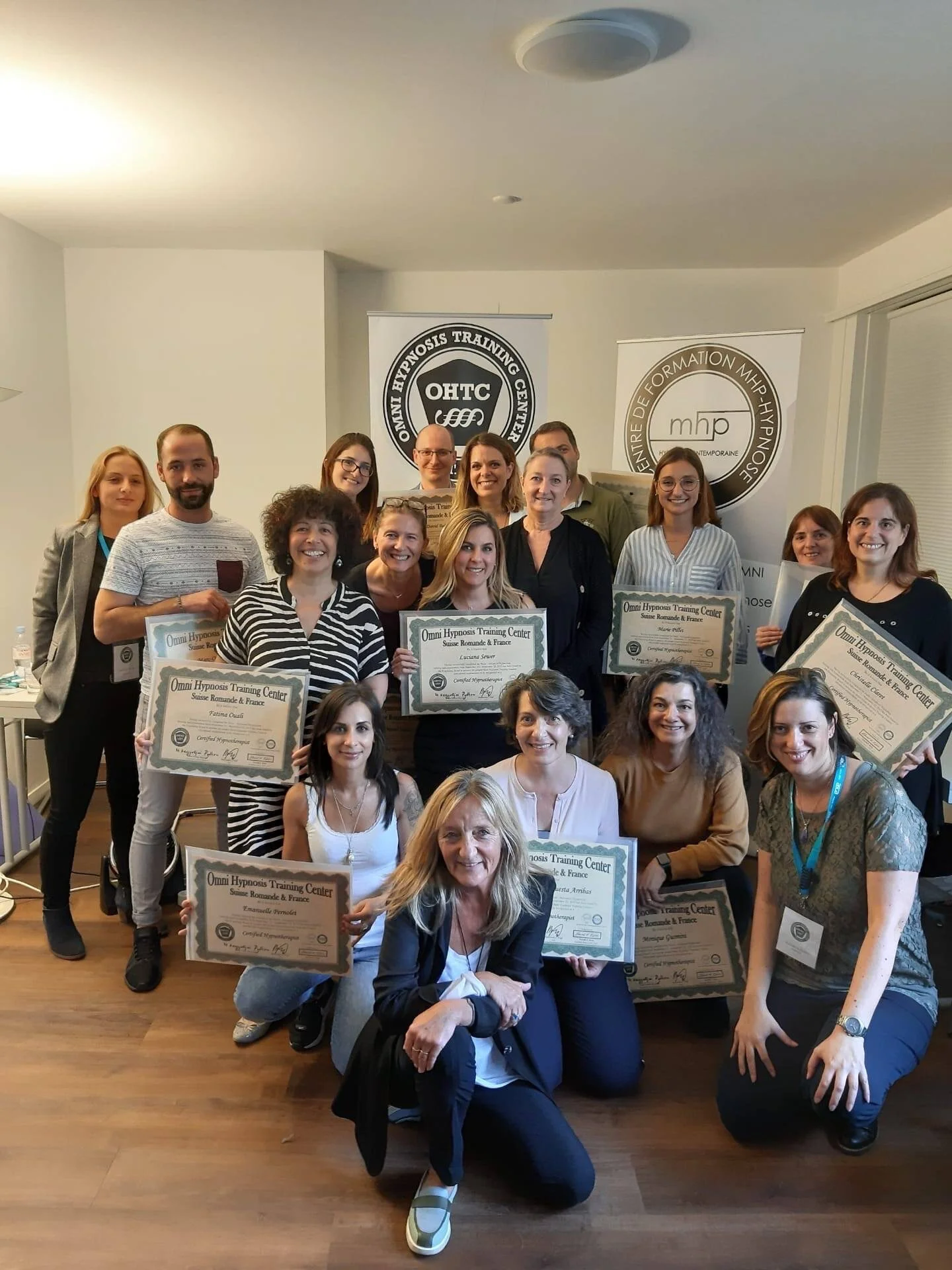 Groupe de personnes posant avec des certificats lors d'une formation en hypnose à l'Omni Hypnosis Training Center, Suisse Romande & France.