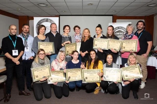 Groupe de personnes tenant des diplômes lors d'une cérémonie de remise de certificats.