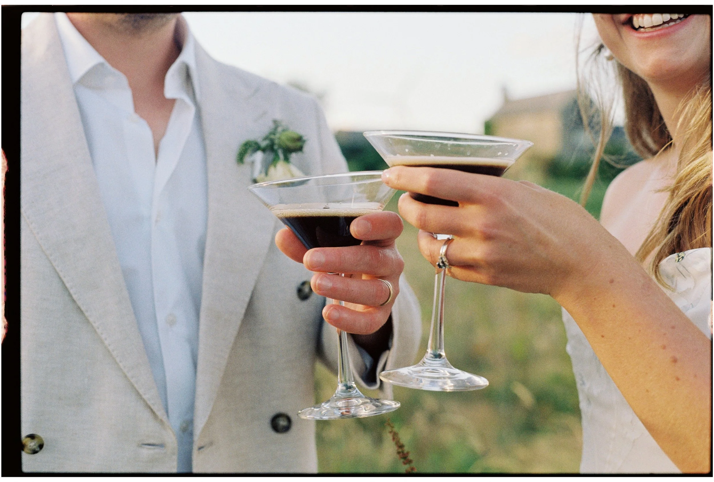 Close-up of Bride & Groom toasting with cocktails at their wedding at ash barton outdoors.
