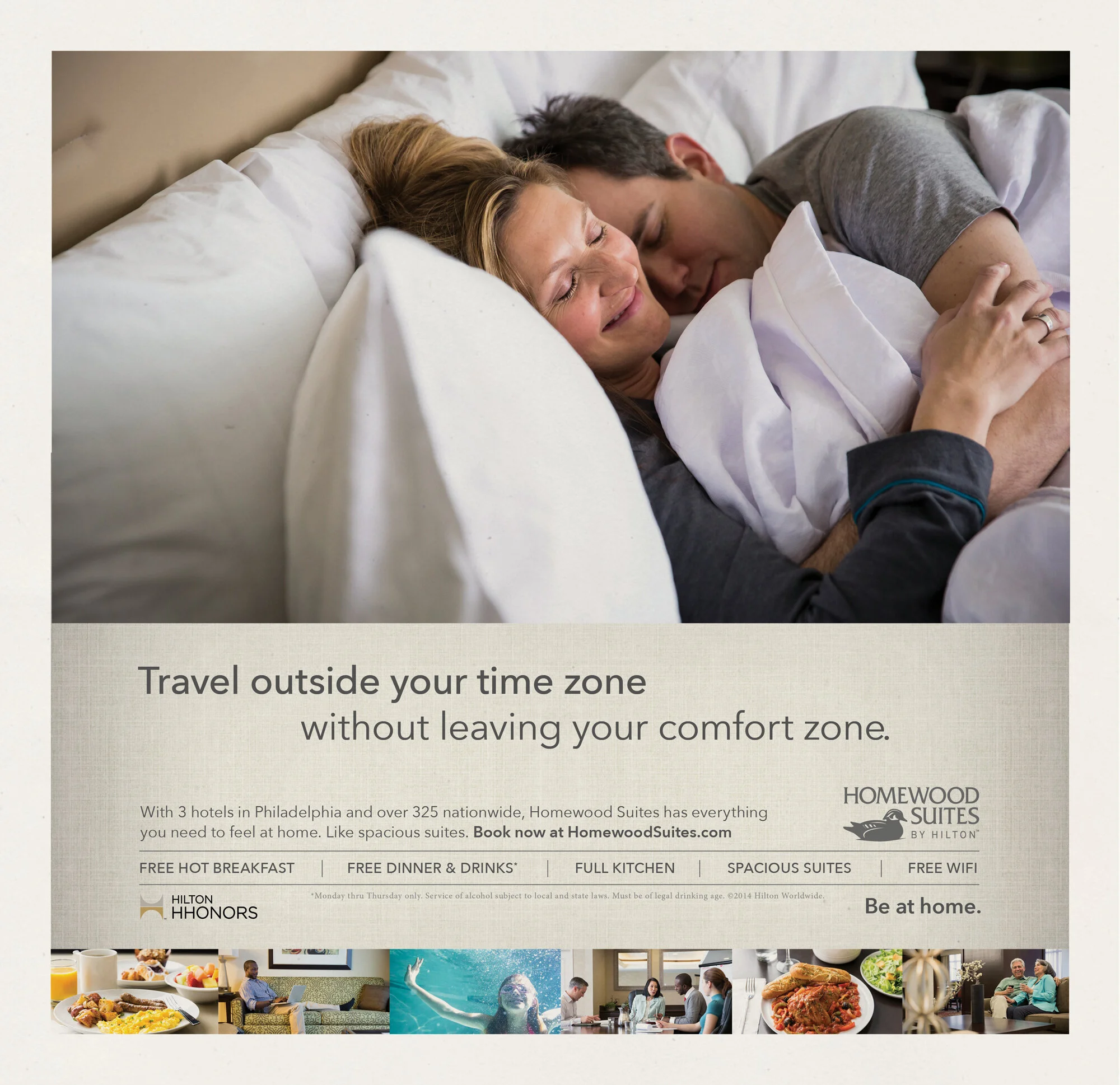 A smiling woman and a man sleeping next to each other in bed, hugging in an advertisement for Homewood Suites Hotels.