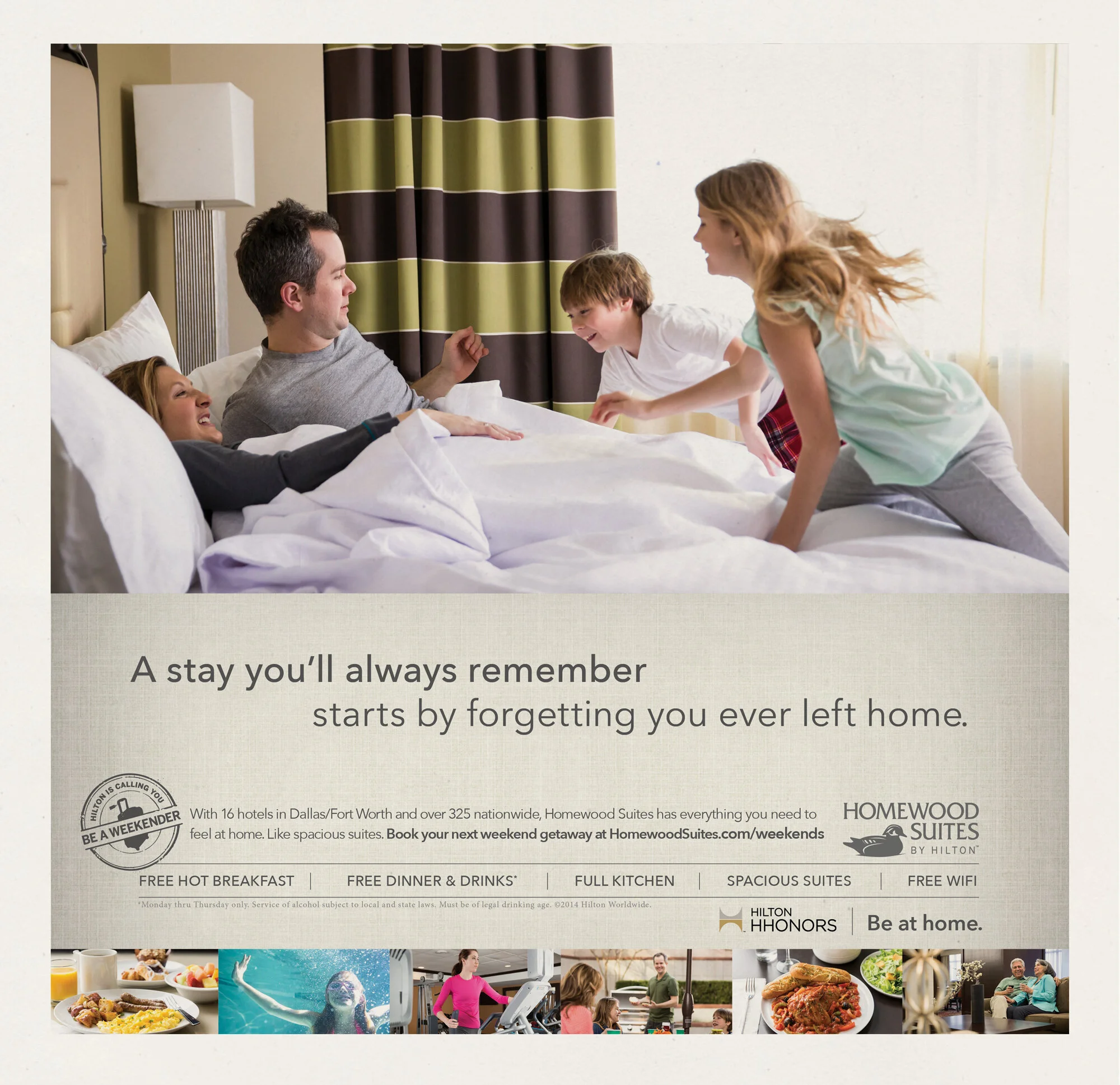 Family of four enjoying playful moment in bed at hotel, with children climbing onto parent, in a hotel room with curtains and lamp. An advertisement for Homewood Suites Hotels
