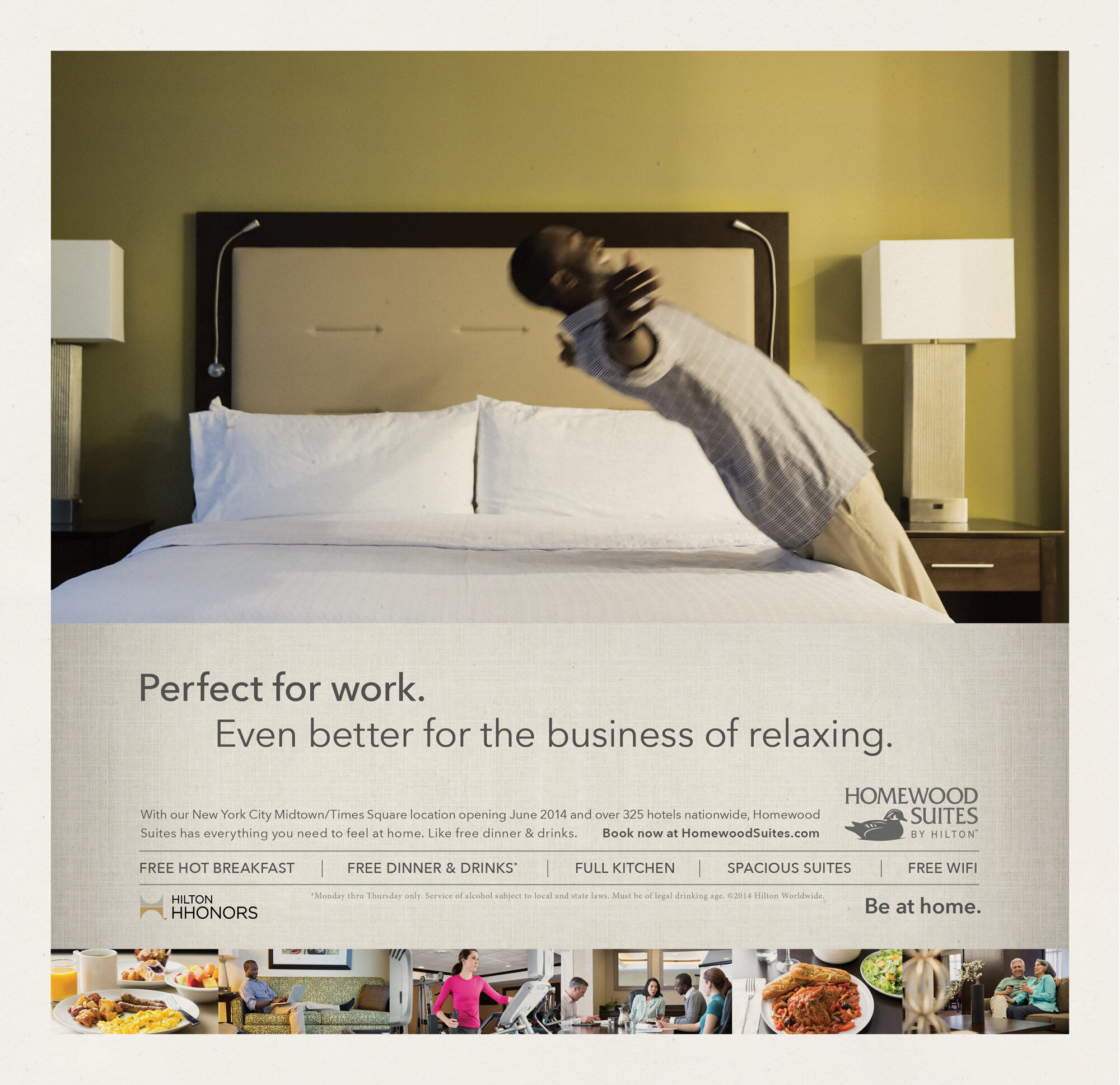 A man leaning back in bed in a hotel room, stretching or yawning, with white sheets and pillows, and two nightstands with lamps on either side. An advertisement for Homewood Suites Hotels