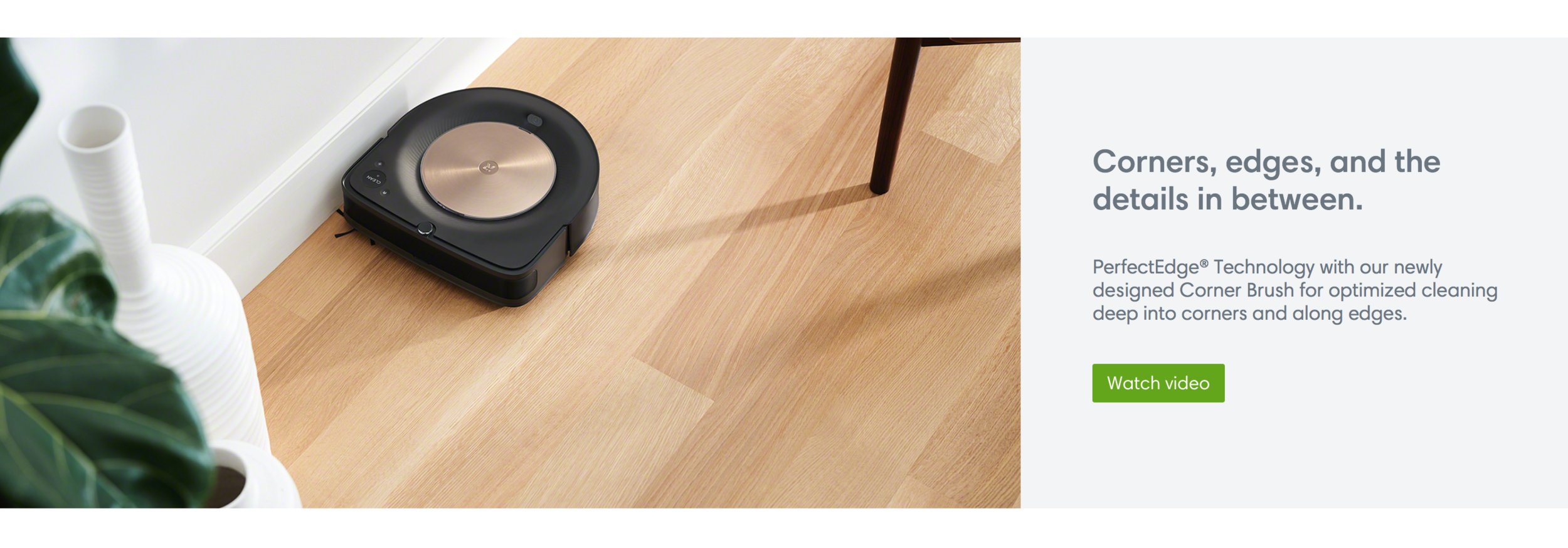 Robotic vacuum cleaner cleaning hardwood floor near a white vase and a green leafy plant, with a chair leg visible. Text promoting corner and edge cleaning technology with a watch video button. A screenshot of iRobot's web site.