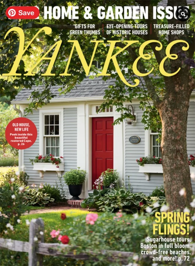 Cover of Yankee magazine featuring a charming Cape-style house with red door, white siding, flower boxes, and lush garden, surrounded by trees.