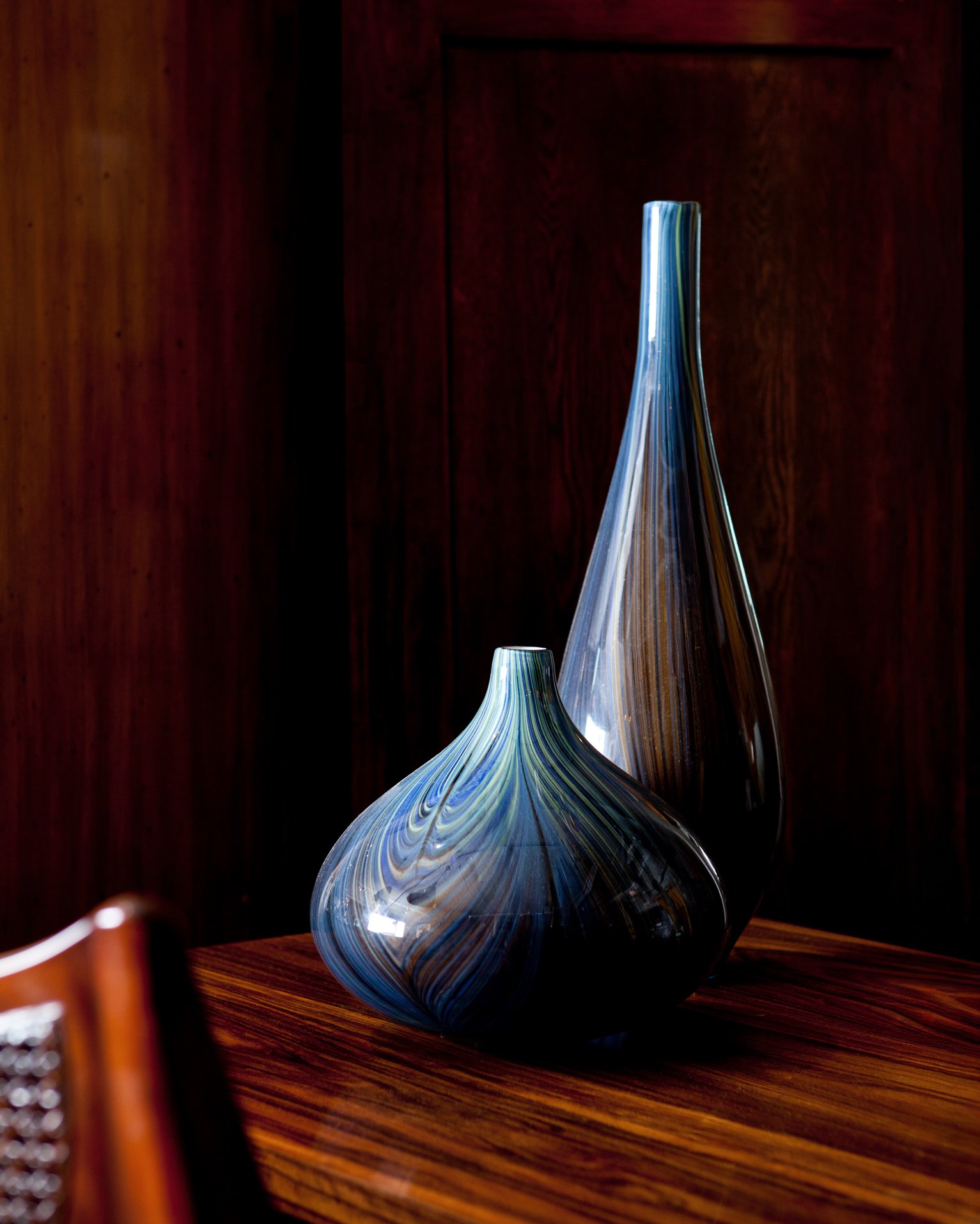 Two modern glass vases on a danish modern table.